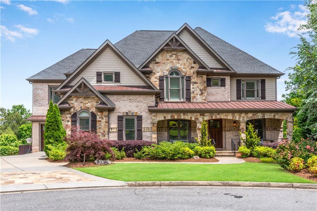 Welcome home to this exceptional custom built 4 story craftsman style entertainer’s DREAM HOME w/ elevator, upper & lower finished basements, 2 full kitchens, primary bedroom wing, zero entry saltwater heated pool, & 3 car garage located on a cul-de-sac in desirable Fernwood Creek, a swim/tennis community! Built for herself & family, this is a local HGTV star’s personal residence with functionality & luxurious upgrades built unlike any others! The curb appeal is a stunning blend of brick & stone façade w/ covered front porch & swings! As you enter, you are greeted by an arched brick foyer w/ an executive home office featuring exotic granite countertop waterfall desk & matching cabinetry w/ barn door close! A bright dining room is to your left & butler’s bar. Home has high-end crown molding & trim & hardwood floors throughout. The family room has large wooden ceiling beams, elevator entry, fireplace w/ built-in cabinetry, all with a view of the staircases. Chef’s kitchen features high end SS appliances-vent hood, Thermador range & refrigerators, dual dishwashers, dual microwaves, expansive island, a hidden walk-in pantry, leathered granite counters, dumbwaiter that goes from the kitchen up to the primary bedroom, & doors out onto the upper deck. Garage entry is located off kitchen & has surrounding built-in cabinets for storage needs & an EV charger! Also located on main is a half bathroom and an ensuite guest bedroom. Make your way upstairs & discover the luxurious primary bedroom wing! The bedroom features vaulted ceilings w/ beams, custom lighting, & gorgeous stone fireplace w/ built-in bookcases (left bookcase opens into a secret hidden home office!) The stunning oversized primary bathroom is a spa retreat w/ curved dual vanities, soaking tub that fills from the ceiling (2-way mirror by the tub is a hidden TV), total surrounding steam shower w/ heated tiles on the wall, bench, & tile floors, dual shower heads, & glass door. Off the bathroom are 2 massive his/her designer walk-in closets w/ tons of storage shelves & glass doors for all of your clothing, handbags, and shoes- one closet has a built-in LG clothing steamer, an island w/ quartz, & a wine cooler making getting ready to go out the best pregame! Lastly in the primary bathroom are private dual water closets so you never have to share! Located upstairs is another elevator entry, a laundry room with double washers & double dryers plus a sink, & 3 more spacious ensuite bedrooms! Here is where it gets fun- the basement has a basement! Make your way downstairs to the upper basement where you are met with a theater room, a 6th bedroom w/ full bathroom (currently a gym), elevator entry, and a beautiful game room for endless fun! This upper basement has exterior backyard access to a secluded covered back porch w/ under decking & a beautiful spiral staircase down to the pool. The lower basement is where the parties happen! Enjoy a 7th bedroom w/ full bathroom + urinal, spacious living room w/ the last elevator entry, another stunning full kitchen with masculine touches, more high end appliances, a wall to ceiling bar w/ brick backsplash, bartender sinks, & floating shelves, massive L shaped island, granite counters, hunky metallic vent hood, & black cabinets. A favorite feature is the invisible wall to ceiling glass accordion doors that open out to another backyard covered patio w/ gas grill & outdoor kitchen! This backyard oasis has a heated saltwater pool, large waterslide, hand planted climbing jasmine, spa w/ waterfall, imported palm trees, flat grassy area all completely fenced in with stairs up to the driveway for guest entry! This home is complete with AirRenew drywall in entire house, insulation between every floor, auto clean pool, Rennai tankless water heaters, MyQ system for garage doors, passing radon test, & duration exterior paint. Located just minutes to downtown Roswell, Woodstock, & Alpharetta the trifecta- this makes the subdivision an unbeatable location!