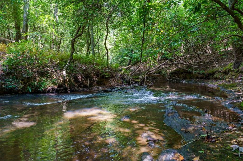 Embrace the serene beauty of North Georgia with this exceptional 1.75 acre residential building lot in Jenny's Cove. Nestled along the picturesque Jenny's Creek with an impressive 296 feet of creek frontage, enjoy the soothing sounds of a year-round, fast-flowing creek, which runs through this picturesque property. This is the perfect blend of convenience and seclusion, with close proximity to Cleveland, Helen and Dahlonega. Bring your own floor plans or collaborate with our local & trusted custom home builder Red Setter Homes to design your dream home. Construction financing is also available, making it easier than ever to turn your vision into reality. Situated amidst mature Mountain Laurel, Rhododendron, Hemlock, and Hickory trees, this lot provides a peaceful retreat surrounded by nature's splendor. This property is also a natural habitat for deer and turkey, offering an opportunity to witness these creatures in their element. This lot's gently sloped terrain offers the perfect canvas for your vision. Whether you envision a cozy weekend retreat or a full-time residence, this lot allows for a cabin with a basement and the potential for awe-inspiring views. Don't miss this opportunity to create your own private oasis in one of North Georgia's most desirable locations. Schedule a showing today and start planning your future in Jenny's Cove! Please note Creekside Dr is a private road. Additional lot located at 3B Beachwood Dr & shared well parcel are available. Ask about our owner financing options and packaged deal for all 3 parcels.