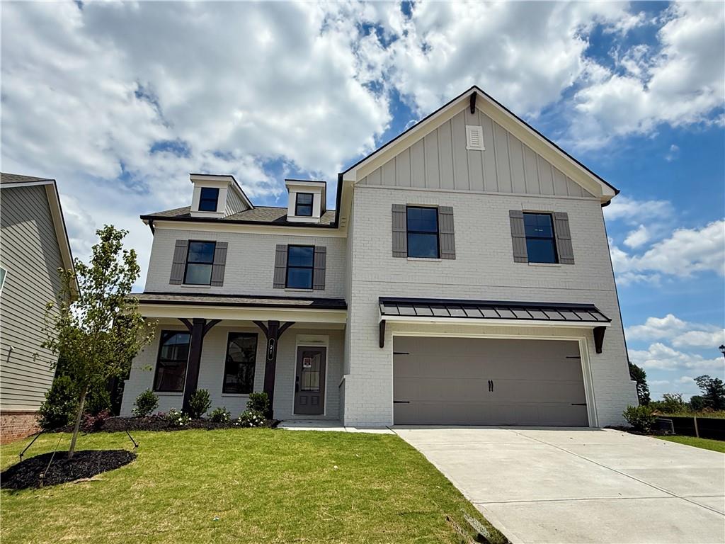 View of front of home with a front yard, a garage, covered porch, driveway, and a shingled roof