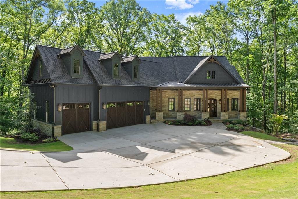 EXQUISITE LUXURY LIVING IN THE NORTH GEORGIA MOUNTAINS! Welcome to this extraordinary 5-bedroom, 5.5-bath custom built Craftsman mountain-style home, offering 5,707 sf of impeccable design and craftsmanship. Completed in 2023 and barely 1.5 years old, this home blends timeless elegance with cutting edge features in one of Georgia's most sought-after gated golf communities. Set above the Chestatee River with direct access to both the River and the award-winning golf course, this estate is a private mountain retreat offering the very finest in luxury living. MAIN LEVEL ELEGANCE (2,873 sf): Step inside to soaring 12-foot ceilings, 8 ft doors, and an open-concept plan ideal for entertaining and outside living. Italian-imported porcelain accents highlight the elegant fireplace, range hood, and the spa-like master bathroom. Pocket sliding doors seamlessly connect the great room to the covered patio, complete with a built-0in kitchen, stone fireplace, motorized screens and electric heaters for year round comfort. The chef's kitchen features high-end appliances, quartz countertops, a hidden butler's pantry with built-in Miele coffee system, and a wine refrigerator. Also on main is a showstopping vaulted office and a private guest bedroom with en suite bath. The serene primary suite on main boasts coffered ceilings and access to the back patio. The master bath includes a floating double vanity, backlit mirrors, bidet, jacuzzi soaking tub, and a walk-through closet that connects tot he main-level laundry room for ultimate convenience. TERRACE LEVEL LUXURY (2,392 sf): Descend via stairs or elevator to a fully finished terrace level with it's own full bar and second kitchen, a theatre room, an expansive entertainment area, a 2nd laundry room featuring a built-in dog shower. Two spacious bedrooms with en suite baths offer comfort for family and guests. Walk out to the tiled patio with a hanging daybed, then follow the pathway to a flagstone fire pit and alfresco dining area, all softly illuminated with ambient lighting. BONUS GUEST QUARTERS ABOVE GARAGE (442 sf): Above the oversized 3-car garage is a fully furnished private guest suite compete with a large bedroom, kitchenette, and full bath - perfect for extended stays or multigenerational living. The exterior of this magnificent estate will captivate all that pass by with it gas lanterns, designer garage doors and beautiful professional landscaping. This is a rare opportunity to won a breathtaking custom estate in the foothills of the North Georgia mountains - offering serenity, sophistication, and seamless indoor-outdoor living. A TRUE MUST-SEE! Achasta is the ultimate mountain retreat - offering something for everybody, a Jack Nicklaus Signature Golf Course and Pro-Shop, Swim/Tennis, Pickleball, 8 Hiking Trails, Fishing, Kayaking, Tubing, Restaurant and Clubhouse that hosts countless Country Club events. Join one of the many social clubs enjoyed by Achasta residents. Just minutes away you can experience the hallmark town of Dahlonega - named “2023 #1 small town in Georgia” by southern living magazine and one of the "10 most beautiful mountain towns in Georgia" - full of festivals, eateries, music, wineries outdoor adventures, shopping, a new Northeast Georgia Medical Hospital and a brand new Publix! Easy and quick access to ga 400. Atlanta is a quick one hour drive south, making Achasta's location highly desirable! Come and experience for yourself what makes Achasta so remarkable and why this lot is perfect for your custom mountain home!