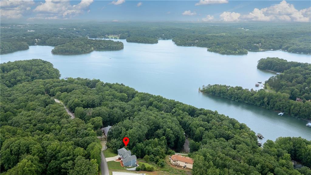 STUNNING LAKE LANIER & MOUNTAIN VIEWS from every level and nearly every room of this energy-efficient home! The photos truly don’t do it justice. Enjoy breathtaking views just minutes from all that Gainesville has to offer.
You’ll be wowed the moment you step inside by the beautiful hardwood floors, soaring ceilings, and abundant natural light pouring through oversized windows. The main level features the primary suite, while a few steps up you’ll find a spacious bonus room currently used as a media room—perfect for a guest suite, office, or additional bedroom.
The lower level offers two bedrooms, a full bath, a massive family room, and access to an expansive lower deck—all with amazing views. The daylight basement below is unfinished and ready for your expansion dreams, complete with high ceilings and tons of potential.
Host gatherings and parties that will wow your friends with stunning lake & mountain views, and enjoy being just 2.7 miles from Little Hall Park for easy lake access. This home is the perfect blend of peaceful privacy and convenience—plus views you simply won’t find in Gainesville!