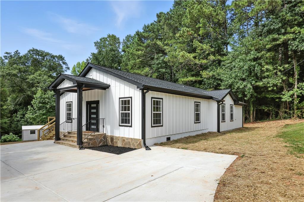 A newly built modern farmhouse on 1.27 acres with no HOA, just minutes from Milton, Alpharetta, and Canton. This one-level ranch blends clean design with peaceful, easy living. Inside, the open layout feels bright and airy with wide-plank hardwood floors, recessed lighting, and a seamless flow from the living room to the designer kitchen, where quartz countertops, stainless appliances, and custom cabinetry make everyday living and entertaining a breeze. The oversized back deck invites morning coffee with wooded views or quiet evenings under the stars. The spacious owner’s suite features a large walk-in closet and a beautifully tiled bathroom with walk-in shower and matte black fixtures. A generous backyard, storage shed, and flat front lawn offer plenty of space to play, garden, or simply unwind. Whether you're upsizing, downsizing, or looking for a fresh start, this home delivers comfort, charm, and room to breathe.