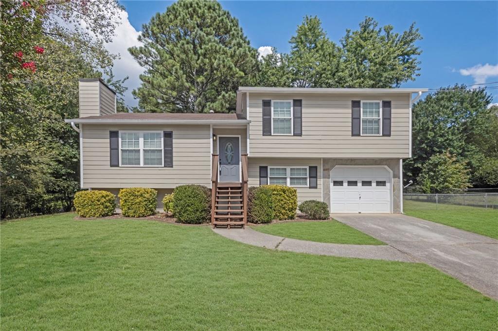 Check out this newly updated home in Douglasville, GA, offering a perfect blend of modern upgrades and charm! It's an ideal starter home situated in a quiet neighborhood, complete with a large, level lot and stunning mature trees. Inside, you'll find vaulted ceilings in the family room, complemented by a cozy stone fireplace. The open-concept kitchen provides a clear view of both the family room and dining area, making it perfect for entertaining. The dining room seamlessly extends to a spacious deck, offering an incredible view of the large, fenced backyard, which provides ample space for various activities. Upstairs, the home features a master bedroom with a private bath, along with two additional bedrooms that share a separate bathroom. The entire house is move-in ready, having just received fresh paint both inside and out, as well as new flooring throughout. Its location provides quick access to shopping, dining, and groceries, and it's just minutes from HWY 20 and local attractions like Sweetwater Creek State Park and Six Flags Over Georgia. Plus, there's no HOA! This is truly an opportunity you won't want to miss.