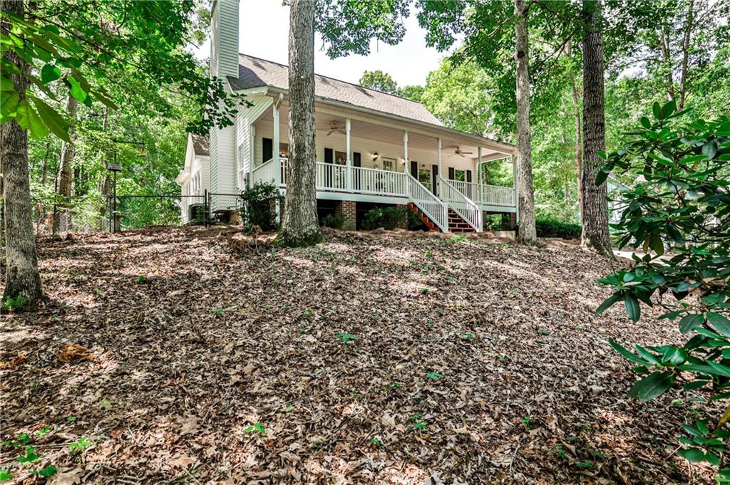 Your Private Hilltop Paradise Awaits!
Escape subdivision living to this serene, private, and well-maintained home north of metro Atlanta, offering ultimate freedom and space. Step onto the huge, welcoming front porch. Inside, find warm hardwood floors on the main, including an oversized master suite with a large double-vanity bath. The beautiful sunroom is open to the kitchen and family room. Upstairs features two spacious bedrooms and a full bath.
The basement apartment offers an exceptional opportunity for extended family or potential income, complete with a private entry, dedicated parking space, full kitchen, bath, bedroom, living space, storage, and luxury vinyl plank flooring.
Situated on an almost-acre level lot at the end of a long, gentle driveway, this oasis boasts plenty of parking for your boat, camper, ATVs, and vehicles. A detached two-car garage is ideal for your cars or as a workshop. Enjoy more privacy than a subdivision, and with no HOA, you have unmatched freedom. Located less than 10 minutes to GA-400, prime shopping, and restaurants, you're also very close to Lake Lanier, with easy access via Thompson Creek Park less than a 5-minute drive away.
Have peace of mind knowing that it includes a 1.5-year-old water heater, a 5-year-old roof, and newer HVAC equipment. Whether you seek a private sanctuary, a versatile family estate, or a home with income potential, this extraordinary piece of paradise awaits!
