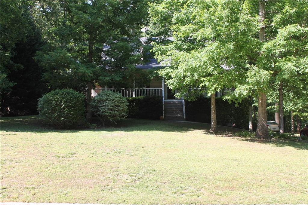 The wrap around rocking chair front porch welcomes you home to this charming ranch on a wooded lot. The master is on the main level. Master bath has double vanities, garden tub & separate shower & walk in closet. Half bath adjacent to main living space. Wood burning fireplace in living room. Eat in kitchen features hardwood floors & walk in pantry. *All kitchen appliances stay* Two additional bedrooms & full bath upstairs. Deck off the kitchen overlooks large backyard with two outbuildings. Large unfinished bonus room & stubbed bath in basement. **USDA Loan Eligible**