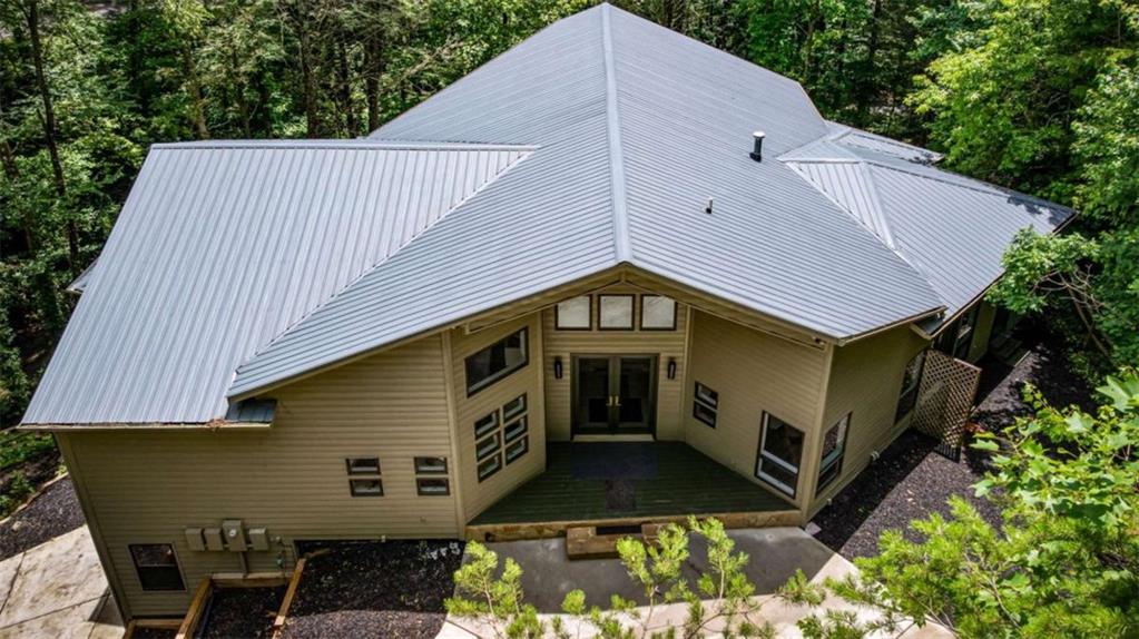 Cascading Trout Stream, private wooded acreage, and stunning architecture-this mountain estate has it all! Nestled on 5.84 acres and backing up to the National Forest, this 5 bed, 5 bath custom tri-level home offers over 6,500 sq ft of extraordinary living space with unmatched privacy and natural beauty. A charming wooden bridge leads you across the stream and into a true mountain retreat. Inside, you'll find a grand vaulted foyer with highlight windows, soaring ceilings, and a unique layout filled with thoughtful design and a chef's kitchen with high-end Gaggenau appliances. The tri-level floor plan provides multiple living areas and flexible space-ideal for a family compound, multigenerational living, or hosting guests. 2nd kitchen in basement and Media Room. Enjoy a 3-car garage, concrete driveway, and the serenity of surrounding water and forest views. With direct access to National Forest trails, this is a mountain biker's dream come true-ride, hike, or explore the Cohutta Forest. A rare opportunity to own an architectural gem in one of North Georgia's most scenic and peaceful settings.