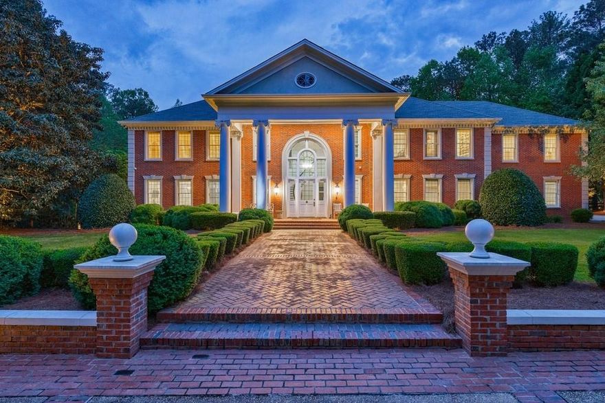 Stunning property in sought-after Cameron Crest Farms. This estate is truly one-of a kind on 5+/ acres with walking trail, pond, privacy among the trees and woods, lake front, gazebo and barn. The gated entrance leads to the tree line driveway and parking pad. Front porch opens to grand entrance foyer with stone flooring and spiral staircase. Large living room overlooks the park-like backyard. The light filled kitchen in the back of the house offers an oversized island, stone counters, stainless steel appliances and opens to the breakfast area with fireplace. The kitchen is also complete with a large walk-in pantry. Main level has formal dining room and family room off of the kitchen as well. Sought-after primary suite on main overlooks the backyard with floor to ceiling windows and is complete with a fireside sitting area. Luxurious primary suite has double vanities, separate tub and shower. Spacious walk-in closet has island and laundry area. The grand staircase leads to 5 bedrooms, 4 full bathrooms and several bonus rooms for dual offices and/or playroom. Upper level includes laundry room with sink and a hidden space above the garage that could be used as a bedroom, au-pair suite, office or man cave, it also offers a large walk-in closet and full bathroom. The grounds are absolutely breath-taking for kids, pets and entertaining. Close proximity to all that Johns Creek has to offer but the farm-like setting is so special, private and serene.