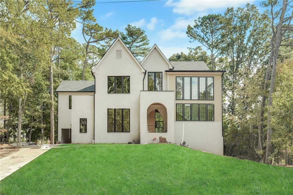 Come see this inviting new construction home nestled in a prime Sandy Springs location, offering the perfect blend of elegance, comfort, and modern living. Step through the portico arch entry into a grand foyer with soaring 10-foot ceilings and stunning hardwood floors that flow throughout the home. The main level features a guest suite with a full bath, a separate dining room with vaulted ceilings—ideal for entertaining. The heart of the home is the designer kitchen, complete with top-of-the-line appliances, custom cabinetry, and a spacious scullery, all overlooking the family room and a cozy fireplace. A mudroom off the kitchen adds convenience, while thoughtful design elements create a seamless flow for everyday living. Upstairs boasts vaulted bedrooms, and a luxurious primary suite with a spa-like bath featuring custom walnut double vanities, a soaking tub, separate shower, and large walk-in closet. The upper level also includes three additional ensuite bedrooms and a convenient laundry room, providing space and functionality for family and guests. Enjoy outdoor living at its finest with a covered porch featuring a fireplace overlooking a private backyard with plenty of room for a POOL. This 5-bedroom, 5.5-bath home also includes a 3-car garage and an UNFINISHED basement—offering endless potential for customization to suit your lifestyle. Perfectly situated in the heart of Sandy Springs, this home combines the tranquility of a private setting with the excitement of nearby premier shopping, dining, and entertainment. Every detail has been thoughtfully designed to offer both comfort and sophistication in one exceptional home.
