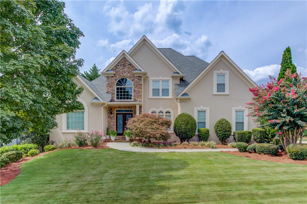 Located in the highly sought after Hamilton Mill community, this 6 bedroom, 4.5 bath home offers stunning golf course views of the 10th green and 11th tee box.The spacious open floor plan is filled with natural light, featuring a two story foyer, separate dining room, and private office.The owner’s suite is conveniently located on the main level. Enjoy multiple gathering spaces with fireplaces in both the main living room and the finished basement family room. The terrace level is fully finished, offering endless options for entertaining, recreation, or guest space. Outside, the beautifully landscaped yard provides a serene backdrop for golf course living.Hamilton Mill residents enjoy resort style amenities including two swimming pools, tennis and pickleball courts, sidewalks, streetlights, a swim team, golf course, and clubhouse all within the top-rated Mill Creek school district.