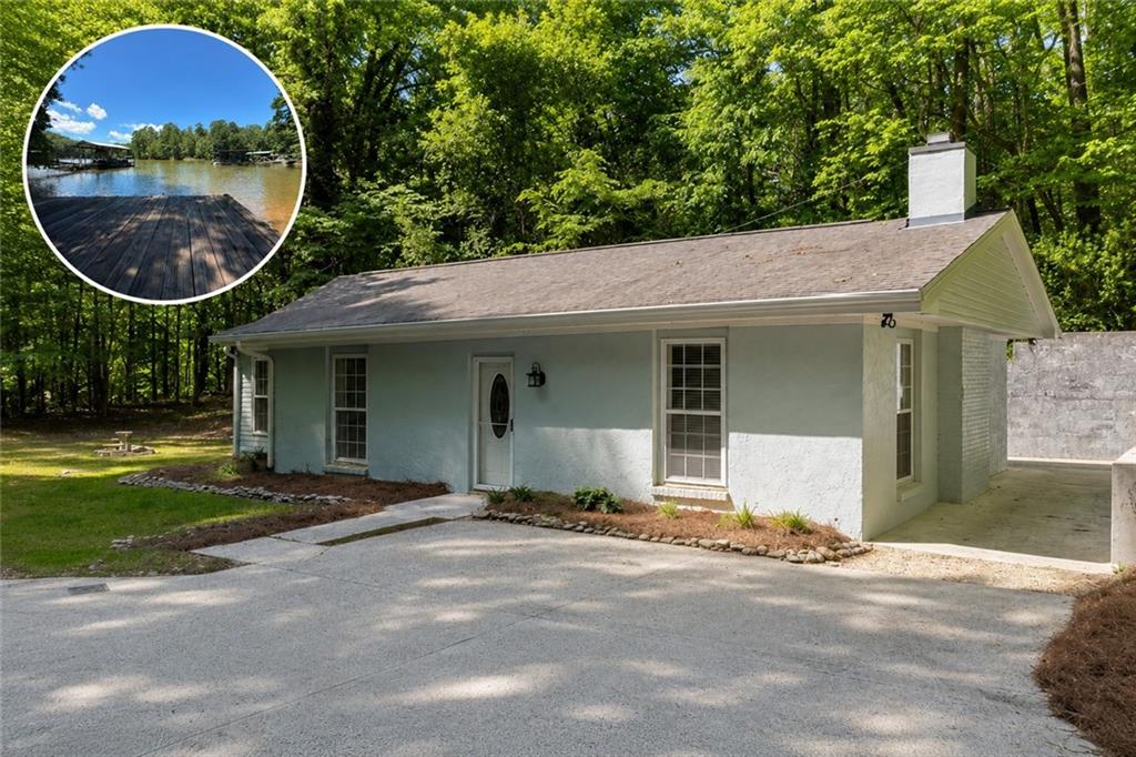 Light blue stucco exterior with white trim, featuring a prominent chimney, a covered entry, and a paved driveway