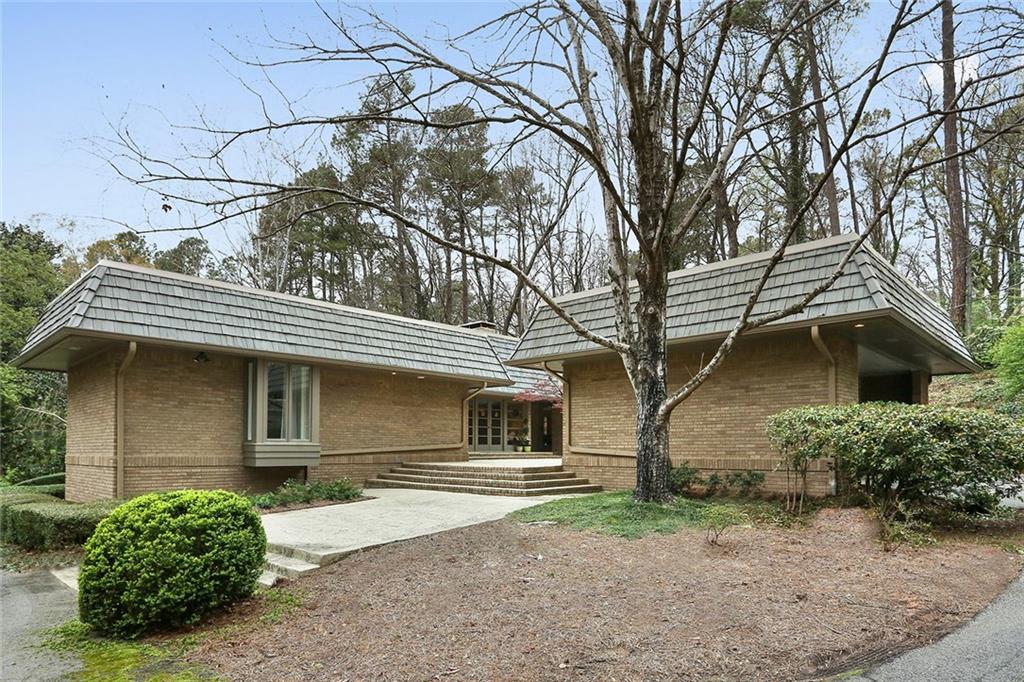 Architect designed 1960's Mid-Century California modern nearly 1 acre lot in a peaceful cul de sac characterized by period details such as open floor plan, walls of glass, sunken living room, masonry and hardwood floors throughout, wood/fabric paneling, circular driveway and 1BR, 1BA separate in-law suite with private entrance. Entertain guest on the private terraces during the summer or indoors on the screened in porch.  Bathrooms and kitchen have been extensively updated. This beautifully renovated Buckhead home is in the award winning Jackson Elementary district.