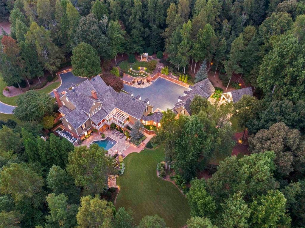 Custom Sophistication/ SPECTACULAR private 2.7 acre paradise in one of Milton GA’s most desired and prestigious neighborhoods- North Valley- award winning schools/ recognized as an area for the highest quality of lifestyle in GA. Close to Alpharetta shopping, dining, entertainment venues. Artfully landscaped/ designed homesite lures you in/ Crab Orchard rock lined drive to carriage house/ through Porte-cochere to carport. Spaces for 7 vehicles. Residence offers timeless appeal, unsurpassed craftmanship, appealing architectural touches. Lavish upgrades/ custom cabinetry, gleaming hardwood flooring, imported tile, outdoor decking is IPE (exotic hardwood), outdoor lighting. Pool cabana/ grilling station/ luxurious Pebble Tech pool/ hot tub/ double waterfalls. You will notice gleaming hardwood flooring/ extensive molding/ timeless style to the design. Have your next dinner party in the formal dining room with fireplace or large family gathering. Formal parlor adjoins gentleman’s office. The heartbeat of the home will be the open kitchen/ center island, fireside family room/ large breakfast room/ deck overlooking pool/private grounds. Breakfast room stairs to a vintage style theatre/ full bath. Main level oversized laundry facility/ an abundance of storage. Owner’s suite/ main level boasts second fireplace/spa inspired bath. Enjoy your deck/ pool view from this retreat. Upper level complete with 4 generously sized bedrooms, 2 full baths/ walk-in closets. Terrace level/complete with family room, stone fireplace, oversized game room, flex room, full bath, soundproof room. Access pool area from terrace lvl. Pool/rear acreage manicured/lighted pathways/ sound. Carriage house boasts large room, full bath/ storage. Pride of ownership is evident.
