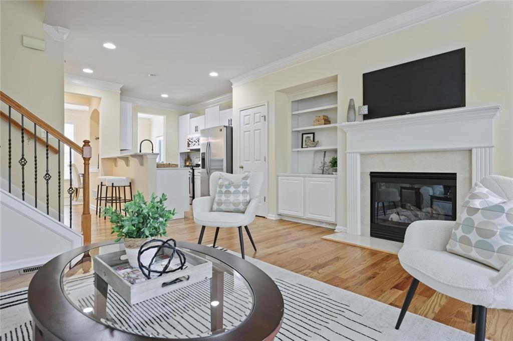 The light filled main level features hardwood floors, high ceilings, crown molding, a separate dining room, and a spacious fireside family room with custom built ins.