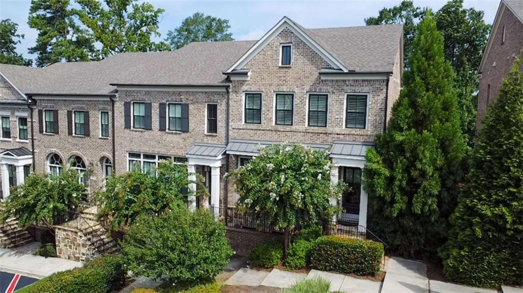 All brick townhome with ELEVATOR, located in the sought-after Arrington Place community in Brookhaven. Designed for today's lifestyle, this boutique enclave offers refined living with an open floor plan and a separate formal dining room perfect for entertaining. The gourmet kitchen is a chef's dream, featuring an oversized island with casual dining, KitchenAid appliances, a custom vent hood over the gas cooktop, glass-front cabinetry with lighting, under-cabinet wine fridge, and pull-out shelving. Rich hardwood floors flow throughout the main level. The spacious living room boasts a cozy fireplace and built-in bookcases, while French doors open to a large deck with stunning Buckhead skyline views. An irrigation system ensures easy maintenance for outdoor spaces. Upstairs, the inviting primary suite includes a private sitting area, deluxe bath with soaking tub, glass-enclosed walk-in shower, double vanity, and an oversized walk-in closet. A second bedroom with en-suite tile bath completes the upper level. The versatile terrace level offers a third bedroom and full bath, along with access to the two-car garage. An elevator services all floors, providing comfort and convenience. Positioned in a prime location within the community, this home overlooks green space and beautifully maintained landscaping. Just minutes from Buckhead, with easy access to Midtown and Emory, this residence combines elegance, functionality, and unmatched convenience.