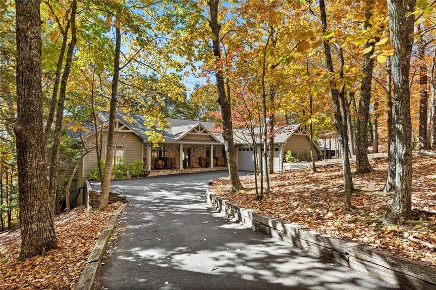 Nestled in the heart of Big Canoe’s prestigious Lakeside neighborhood, this extraordinary 5,000+ square foot masterpiece offers an unparalleled blend of luxury, space, and breathtaking natural beauty. Perched on a wooded 0.73-acre lot, this architectural gem boasts jaw-dropping mountain and lake views that transform every moment into a serene escape. Perfect for those seeking a refined mountain lifestyle. Step into the expansive great room, where 18-foot ceilings and a 40-foot wall of windows frame panoramic vistas, flooding the space with natural light. A majestic stone fireplace anchors this inviting gathering spot, ideal for cozy evenings or lively entertaining. The home's original handcrafted solid wood maple cabinetry, in a light honey finish, extends through the kitchen, scullery and living room, uniting the spaces with timeless craftsmanship. In the kitchen, the addition of glass knobs and a crystal chandelier enhances the space with understated elegance, transforming it into an inviting eat-in area that flows seamlessly into a large screened porch—perfect for al fresco dining with a view. A second screened porch off the luxurious primary suite offers a private retreat to savor morning coffee against the backdrop of tranquil lake and mountain scenery. The main level is designed for effortless living, with a spacious primary suite boasting his-and-her closets, plus two additional bedrooms for guests or work-from-home needs. Take note of the custom-fitted hand-stained solid wood Knotty Alder doors in a warm pecan finish that echo the living room's exposed wood beams, unifying the home with polished rustic character. The terrace level expands the home’s versatility, offering a generous family room with a gas fireplace, two additional bedrooms, a full bath and a large porch—perfect for hosting family, friends, or creating a private recreation haven. With its blend of sophisticated design, expansive living spaces, and seamless indoor-outdoor flow, this home is an entertainer’s paradise and a sanctuary for relaxation. Located in the coveted Big Canoe community, you’ll enjoy access to world-class amenities, including golf, hiking trails, lakeside recreation and a newly renovated club house all while being enveloped by the serenity of North Georgia’s mountains. Schedule your private tour today and experience mountain living at its finest!