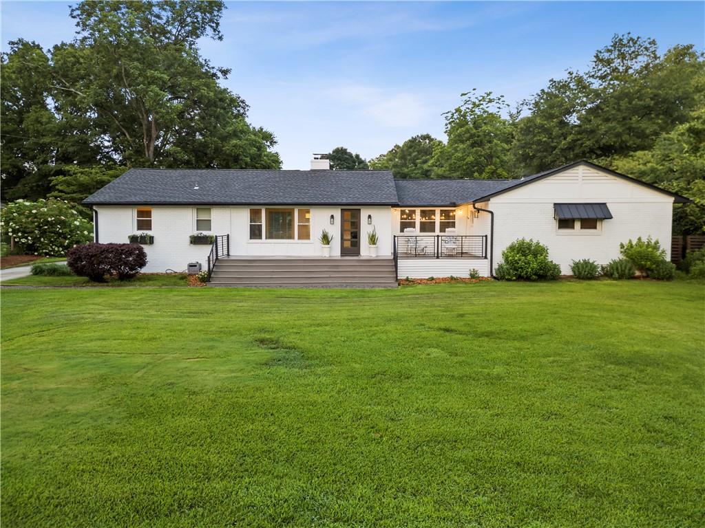 Completely renovated brick ranch blending rustic charm with designer style, this stunning 3-bedroom, 2-bath home with three versatile bonus rooms is filled with thoughtful upgrades including hardwood floors, coffered ceilings, custom accent walls, and built-ins throughout. The inviting rocking chair front porch offers beautiful sunset views, while the fully fenced yard with an automatic security gate provides privacy and peace of mind. Inside, the cozy family room features a brick wood-burning fireplace, and the kitchen impresses with custom cabinets, a breakfast bar, and a brick backsplash. The owner's suite is a spacious and serene retreat. The main bath includes a soaking tub with built-in TV, a separate marble shower, and double vanities. Two additional bedrooms share a convenient Jack-and-Jill layout. The three bonus rooms offer incredible flexibility—perfect for a home office, gym, guest room, or creative studio. The outdoor space is a true homesteader's paradise with mature fruit trees including apple, cherry, pear, plum, and nectarine or peach, along with berry shrubs such as blueberries, blackberries, and elderberry, plus edible perennials like asparagus, strawberries, and sunchokes. A 9 by 21 foot Climapod greenhouse with potting table, automatic louvre skylights, and a solar fan supports year-round gardening. Multiple fenced garden areas include raised beds for vegetables and culinary herbs, all equipped with drip irrigation systems and water tanks, along with a three-stall composting area. A fenced vineyard with six high-yield muscadine vines and a 30 foot custom chicken run and coop with four nesting boxes and sixteen chickens add to the property’s self-sufficient lifestyle. The huge garage offers plenty of space for storage or a workshop. Located within walking distance to downtown Winterville, residents can enjoy concerts at the Marigold Auditorium, art and community classes at the cultural center, the local farmers market at Pittard Park, the Winterville Library, the Farm Stop, and easy access to the Firefly Trail which connects to Athens. All of this is just a fifteen-minute drive to downtown Athens.