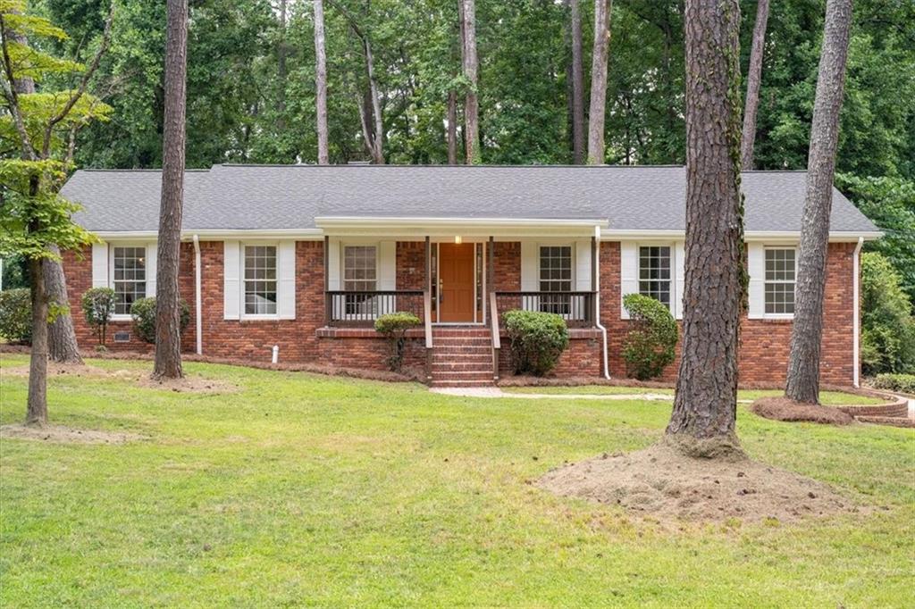 A beautifully renovated ranch in one of Southwest Atlanta’s most nature-rich, connected, and quietly coveted pockets. Located just minutes from Cascade Springs Nature Preserve, Lionel Hampton Park, and the BeltLine’s Westside Trail, this home offers rare access to hiking trails, biking paths, and lush green space - while still being less than 15 minutes from Downtown Atlanta, Hartsfield-Jackson Airport, and I-285. Whether you’re commuting, traveling, or simply seeking the balance of convenience and calm, this location delivers on every front. Step inside to discover a light-filled interior where comfort meets thoughtful updates. The generously sized living room flows into a separate dining area, creating the perfect layout for both daily living and entertaining. The family room features charming beamed ceilings, chair rail accents, a cozy fireplace, and a custom built-in, offering warmth and personality. The renovated kitchen is equipped with white cabinetry, quartz countertops, stainless steel appliances, upgraded backsplash, updated fixtures, pantry, and a sunny breakfast nook for casual meals. The oversized primary suite is a true retreat, complete with a walk-in closet, stylish barn door, and a fully updated en suite bath featuring a new vanity, lighting, and tile shower. Two additional well-sized bedrooms and a fully renovated hall bath offer flexible space for guests, hobbies, or work-from-home needs. A spacious laundry room with a sink, countertop space, and built-in cabinetry adds function and flow, while the partial basement includes a half bath and a 2-car drive-under garage for storage and convenience. Out back, unwind in the expansive screened-in/covered porch or enjoy the separate patio area, all overlooking a private, tree-lined backyard - perfect for entertaining, quiet mornings, or summer evenings under the stars. With its prime location, thoughtful upgrades, and indoor-outdoor lifestyle appeal, 761 Lynn Circle SW is the perfect blend of classic comfort and modern convenience in the heart of Southwest Atlanta.