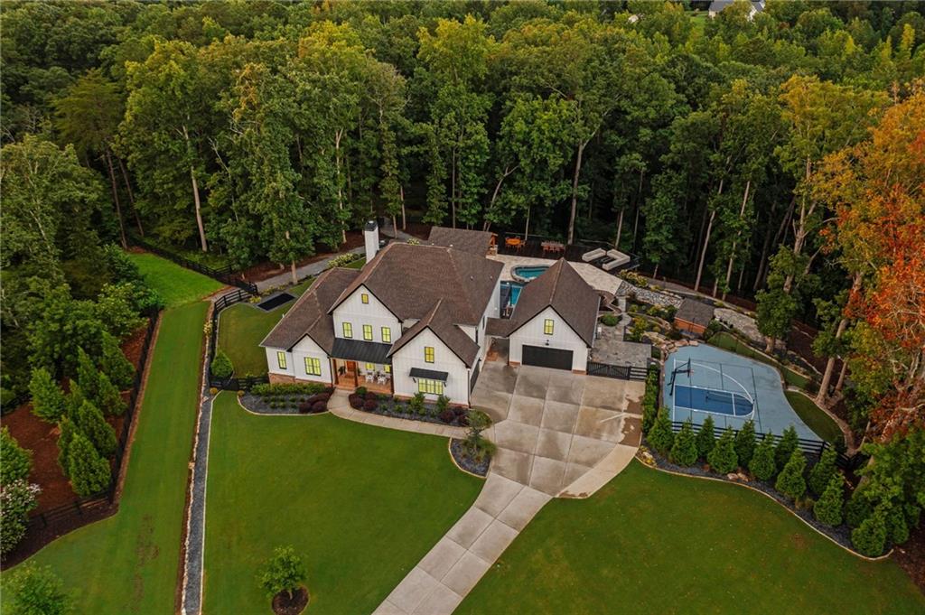 Once-in-a-Lifetime Luxury Estate with Resort-Style Backyard on 2.5 Acres - UNLIKE ANYTHING ELSE ON THE MARKET!
This extraordinary estate offers a rare opportunity to own a property that blends the ultimate in luxury living with resort-style amenities. Situated on 2.5+/- acres of lush landscaped grounds in a prime school district, this home is designed for entertaining, relaxation, and everyday comfort at the highest level. Inside, you’ll find gorgeous modern finishes with cedar beams throughout the main level, an open floor plan with a large family room that includes built-ins, cozy stone fireplace and sliding doors opening the indoors to the outdoors. A massive gourmet kitchen featuring an oversized island with seating for up to 10, quartz countertops, double ovens, oversized refrigerator, and a vented range with hood. A vaulted keeping room/ breakfast area with shiplap and custom lighting adds to the charm of this spectacular home! This luxury kitchen also offers a custom walk-in pantry with a grocery door makes everyday living effortless. The main-level primary suite is a private retreat with soaring ceilings and a spa-like bath including a soaking tub, oversized shower, and double vanity. Owner suite closet includes custom built-ins, island with drawers, makeup vanity/desk and FULL laundry with sink! Upstairs, four spacious secondary bedrooms each offer their own private en suite bath and walk-in closets. A second fantastic laundry upstairs with cabinets and sink. The finished terrace level includes a sixth bedroom, full bath, a state-of-the-art media room with seating for 10 and an incredible sound system, a fitness room, and a rec room. Terrace level also offers a third laundry making laundry a breeze on any floor! A whole-home speaker system carries throughout the interior and exterior, creating the perfect setting for entertainment.
The backyard is a true PARADISE with diving ledges, resort-style slides, waterfalls, grottoes, tanning ledges, and a massive hot tub, along with pickleball and basketball courts, a putting green, and an in-ground trampoline. Outdoor living continues with a full kitchen, outdoor bathroom, sauna, private outdoor shower and spectacular outdoor fireplace tucked in the trees for majestic evenings! Covered and screened deck with fireplace is the perfect spot for morning coffee! Custom lighting enhances both the home and backyard, creating a stunning evening ambiance, while a full irrigation system keeps the grounds lush and a full house generator provides peace of mind. A rocking chair front porch adds classic Southern charm, while the attached two-car garage and detached two-car garage provide space for four vehicles in total. Above the detached garage, a private office / bonus space is ideal for a home office, studio, or man cave. The property also features a private hiking trail that leads directly to Canton Creek and waterfall.
This one-of-a-kind estate combines breathtaking design, unmatched amenities, and an outdoor resort experience unlike anything else on the market.