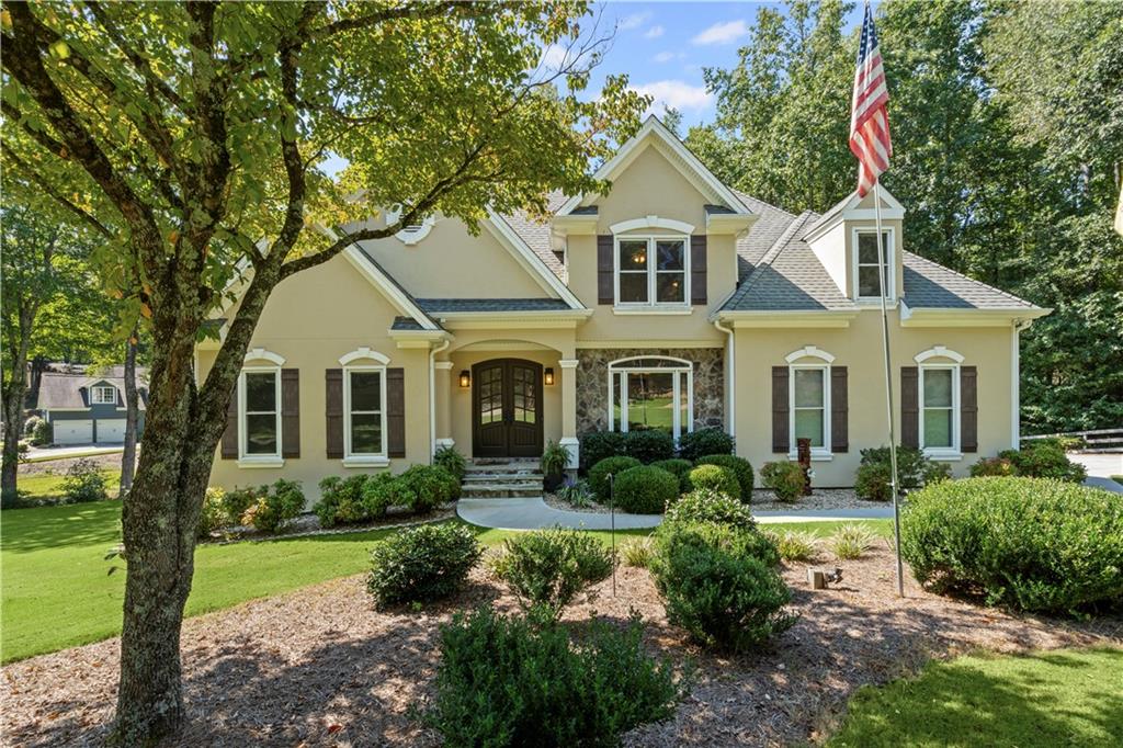 Run, don't walk! This Alpharetta gem with Cherokee taxes won't last! Opportunities like this are rare and this one checks all the boxes. Stunning two story home on a full walk out basement sits proudly on a 1 acre private lot. Step inside to find newly finished hardwood floors throughout the main level. A sun soaked chef's kitchen featuring granite counters and stainless steel appliances opens to the inviting living room and greets you with views of the expansive backyard. Walk out onto your oversized deck off the kitchen to enjoy morning coffee. Need some shade while you're out there? Extend the remote controlled retractable awning to create the perfect spot. The master suite is also on the main with a newly remodeled spa like bath featuring an oversized shower with dual showerheads and a professionally curated closet system. Upstairs, you'll find three spacious bedrooms each with hardwood floors and perfectly tailored closet systems! The finished basement offers an additional bedroom and full bath, plus a wet bar and wine fridge. Perfect for entertaining. Enjoy your outdoor space in all weather on the basement patio with under deck system. The serene backyard invites you out to come meander along the creek and offers tons of space for all of your favorite activities. Garage boasts a sleek epoxy floor, making it ideal for your car collection or workshop. This home is truly a rare find with elegance, comfort, and functionality all in one.