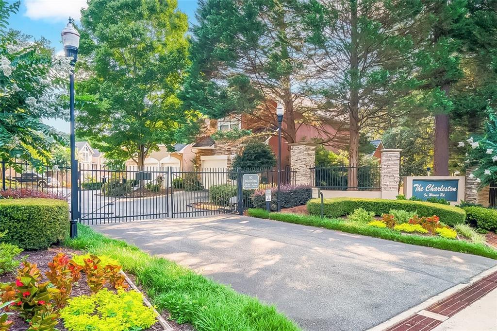 Lock & Leave. This hidden gem in the heart of North Buckhead lives like a large single family home. Tucked away in a quiet enclave of 18 homes, this rare 4-bedroom, 3.5-bath end-unit townhome offers an unbeatable combination of space, architectural elements, natural light, and location. A gated entrance leads you into a beautifully maintained home with a large house-like footprint spanning three spacious levels. Soaring ceilings, a dramatic two-story foyer, a wall of windows, and a unique atrium/patio flood the main level with natural light. The stunning 2-story living room features built-in bookshelves and a cozy fireplace, while the white eat-in kitchen offers ample storage and functionality. The oversized primary suite serves as a private retreat, thoughtfully separated from two additional guest bedrooms and a full bath down a sunlit hallway. The fully finished terrace level includes an additional bedroom and bath—perfect for an in-law suite or home office—along with generous storage space. Additional highlights include a main level two-car garage, plenty of guest parking, sky-high ceilings in the main living area, FEE SIMPLE ownership, low HOA dues (which include weekly yard blowing), and true lock-and-leave convenience. Located just minutes from Chastain Park and Blue Heron Nature Preserve and within walking distance to Publix, Fresh Market, Trader Joe’s, and neighborhood favorites like Fellini’s and La Fonda, this home offers easy living, top-rated schools, great neighbors, and proximity to some of Atlanta’s best parks, shops, and dining. The square footage (which includes terrace level) for the price in the area is unmatched. These townhomes rarely hit the market - do not miss it.