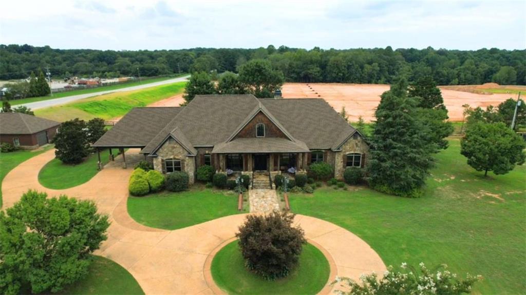 ENDLESS POSSIBILITIES! Amazing opportunity to own this multi-use property in the ever growing Jackson County. PREMIER LOCATION! Primary residence features a 4 SIDES BRICK home with circular driwaway, rocking chair front porch, porte-cochere for convenient covered entry, flagtone patio with outdoor fireplace and built-in grill. Inside find an expansive great room w/stone fireplace, chef's kitchen, 4 Bdrms/3.5 baths, sitting room and more! Additional buildings on the property include 1,500 sq ft workshop and 2,600 sq ft potential guest house or workspace. 6,400 sq ft concrete pad was poured to accomodate additional building with dock high door(s). ALL 3 STRUCTURES FEATURE NEW ROOFS. Situated on 4.66 open acres along Hwy 124 and Jones Road, this could be the perfect location for your next venture!