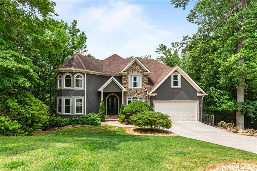 Welcome to your dream retreat—nestled on a private, wooded 1+ acre lot with no HOA and no backyard neighbors, this property is anything but cookie-cutter. This exquisitely updated home offers high-end finishes at every turn, with Brazilian Cherry hardwood floors and stairs, custom craftsmanship, and thoughtful design details from top to bottom. Inside, you’ll find a chef’s kitchen that truly wows: granite countertops, Bosch appliances, a hammered copper apron-front sink, copper prep sink, Sharp drawer microwave, warming drawer, reverse osmosis system, custom handcrafted range hood, and a commercial-size built-in refrigerator. A walk-in pantry and butler’s pantry plus a craft room offer extra function and charm. Every bathroom has been remodeled with luxury materials, including a spa-like primary bath featuring leathered granite countertops, seamless glass shower doors, and an extra-large California closet.The basement is an entertainer’s dream with metallic epoxy flooring, a built-in sandstone bar with granite sink, surround sound, and a private movie room with projector and speakers included. The garage floor features the same luxe epoxy finish.Step outside to a 3-story deck surrounded by serene woods. Gather around the flagstone fire pit or entertain on the private back deck wired for sound. Enjoy outdoor living year-round in privacy. And with Lake Lanier access just across the street, you’re moments from water adventures. In top Forsyth County schools and close to restaurants and shopping. Call about pets!