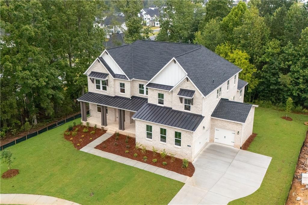 Exceptional New Construction on Private Cul-de-Sac Lot in Brookmeade Trail. This luxury house sits on over half an acre of land nestled within the neighborhood. Designed with elegance and functionality in mind, this residence showcases the popular 'Dunwoody' floor plan with the timeless 'Fairview' elevation—a perfect blend of classic charm and modern sophistication. Step inside to a bright and airy open-concept layout featuring a dramatic two-story great room with expansive windows, and patio doors, that flood the space with natural light. The heart of the home is the gourmet kitchen, complete with a hidden walk-in pantry, a butler’s pantry, a large secondary prep kitchen, and a thoughtfully designed mudroom with access to the three-car garage, which also includes 220V wiring ready for EV charging. Perfect for entertaining and everyday living, the main level also includes a keeping room, a spacious formal dining room, and a private study ideal for working from home. A luxurious main-level guest suite offers added privacy with its own kitchenette, full ensuite bathroom, and direct access to the rear deck—ideal for extended stay guests or multi-generational living. A separate powder room is also located on the main level. Upstairs, retreat to the expansive primary suite, featuring a spa-inspired bathroom with a frameless glass shower, soaking tub, dual vanities, and a generous walk-in closet. Additional guest bedrooms each include ensuite baths, offering comfort and convenience throughout. The daylight walk-out basement is full of potential, offering over two thousand square feet of ready to finish space —perfect for a home theater, gym, game room, or additional living quarters. Enjoy the benefits of a community pool and tennis complex shared with Brookmeade, and the convenience of nearby top-rated schools including the highly regarded Denmark High School. Just minutes to premier shopping, dining, and entertainment at Halcyon and Avalon, and with easy commuter access to Atlanta, this home offers a peaceful setting without sacrificing accessibility.