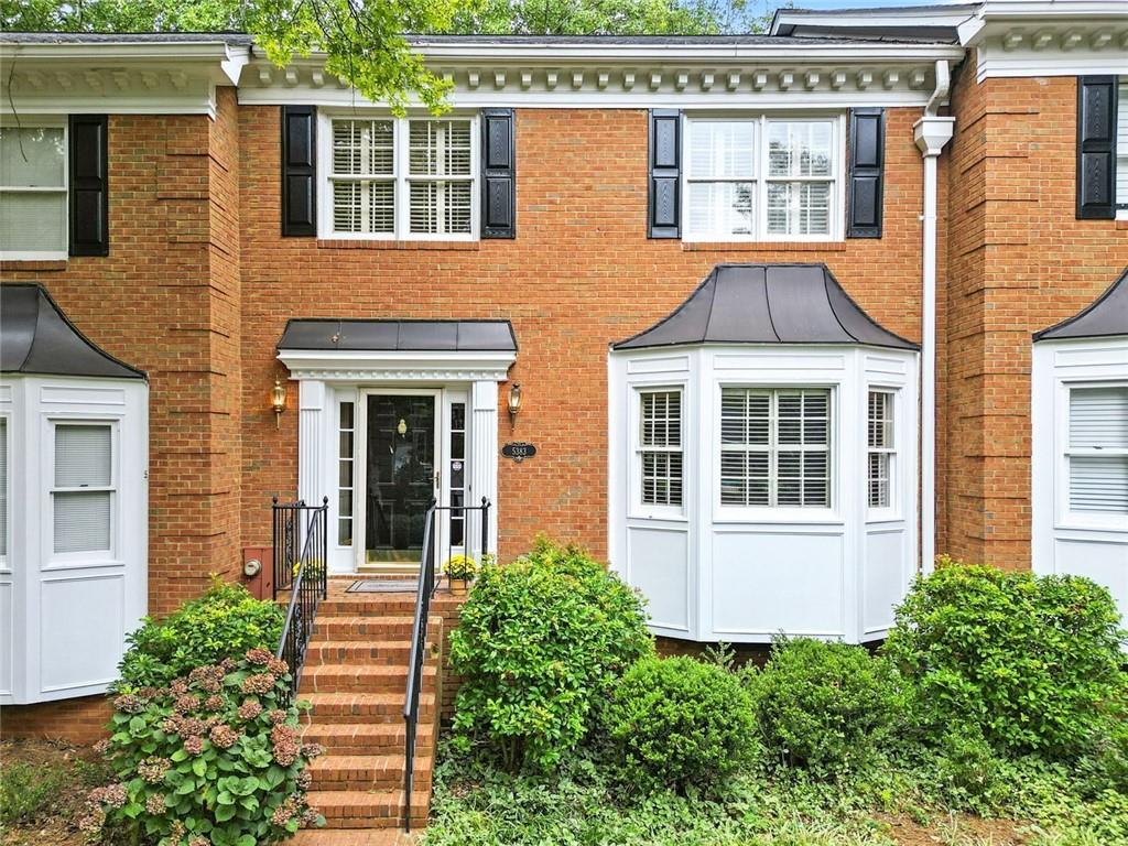 Brick elegance meets modern updates in this thoughtfully maintained three-bedroom, three-and-a-half-bath home with two spacious primary suites. The timeless exterior features stately black shutters, crisp white trim, and a welcoming brick stairway framed by lush landscaping, all while located in a quiet cul-de-sac surrounded by trees.
Inside, the kitchen offers granite countertops, stainless steel appliances, and abundant cabinetry, plus a built-in desk for organization. A pass-through window connects the kitchen to the living space, making hosting effortless.
The living room is anchored by a gas fireplace with a detailed mantel, flanked by built-in shelving, and illuminated by French doors leading to a bright sunroom with skylights. Hardwood floors and crown molding flow throughout the main level, while the finished basement provides fresh flooring, recessed lighting, and barn doors—ideal for a media room, home gym, or office. The fully renovated lower-level bath showcases a marble-topped vanity and a glass-enclosed shower with custom tilework.
Upstairs, two primary bedroom suites offer generous layouts, walk-in closets and private baths. Additional features include a two-car garage with high ceilings and an abundance of storage.
Enjoy a low-maintenance lifestyle with yard care and exterior upkeep covered by the homeowners association. The community pool is just steps away, and you’re within walking distance to Dunwoody Country Club, coffee shops, groceries, restaurants, and more. Located in the high sought after Vanderlyn Elementary School District.