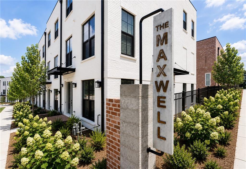 Contemporary multi-story building featuring white brick exterior and dark-framed windows