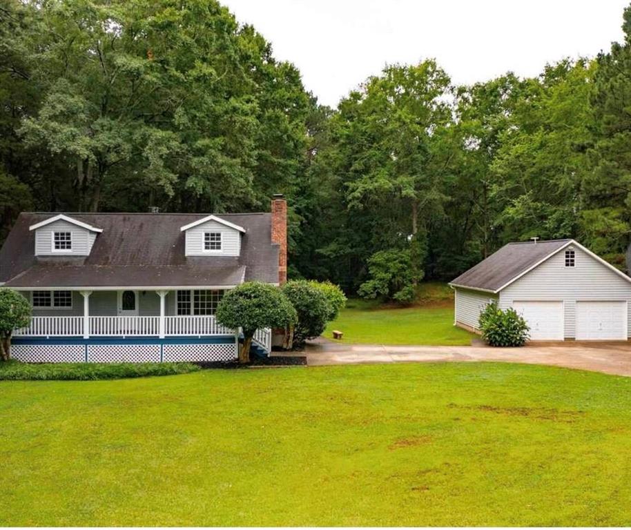 Privacy & Nature - The Best of Both Worlds! Welcome home to this charming rustic retreat nestled on 2 private acres in lovely McDonough, GA! This inviting 3-bedroom, 2-bath home on a full basement offers the perfect blend of tranquility and convenience. Enjoy quiet evenings on the spacious deck or rocking-chair front porch, surrounded by beautiful wooded scenery. Inside, you'll find a cozy living and dining area ideal for relaxing or entertaining, complete with a wood-burning fireplace for those peaceful Southern nights. The basement features two finished rooms currently used as a home theater and office, providing flexible space for work or play. A detached 2-car garage offers parking, storage, or the potential to convert into additional living space. Whether you're dreaming of a cozy home, a place for pets to roam, or simply a serene escape from the city-this property truly has it all!