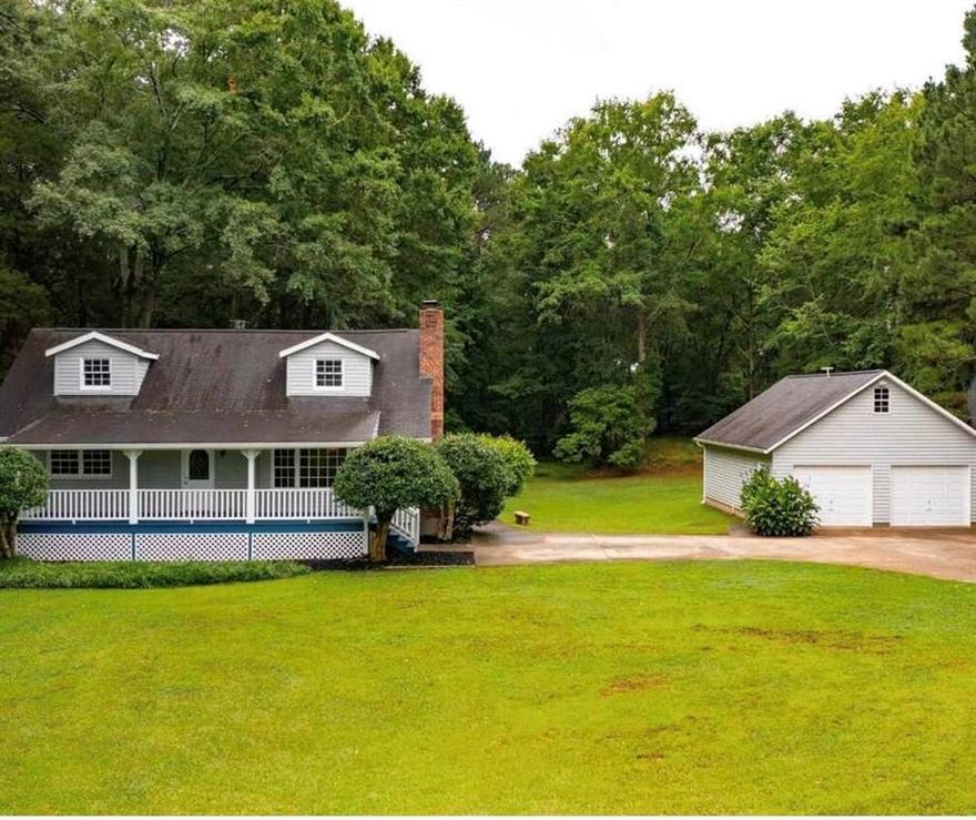 Privacy & Nature - The Best of Both Worlds! Welcome home to this charming rustic retreat nestled on 2 private acres in lovely McDonough, GA! This inviting 3-bedroom, 2-bath home on a full basement offers the perfect blend of tranquility and convenience.  Enjoy quiet evenings on the spacious deck or rocking-chair front porch, surrounded by beautiful wooded scenery. Inside, you'll find a cozy living and dining area ideal for relaxing or entertaining, complete with a wood-burning fireplace for those peaceful Southern nights.  The basement features two finished rooms currently used as a home theater and office, providing flexible space for work or play. A detached 2-car garage offers parking, storage, or the potential to convert into additional living space.  Whether you're dreaming of a cozy home, a place for pets to roam, or simply a serene escape from the city-this property truly has it all!