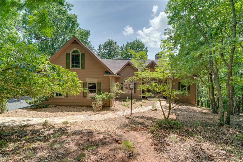 LOCATION! LOCATION! LOCATION! Discover the serenity of mountain living in this charming 4-bedroom, 3-bathroom home nestled on a private and spacious 1.6-acre lot within the prestigious gated Big Canoe community. This meticulously maintained one owner customed built 3700+ sq ft 4 bedroom 3 bath home offers a harmonious blend of comfort and nature and is located only 2 miles from the North Gate and 7-10 minutes to all the amenities. Enter the home via the beautiful meandering flat stone walkway that features a master bedroom suite, bath and large walk-in closet in addition to 2 more bedrooms plus additional bath on the main level, kitchen with breakfast room, great room with 11’ ceiling, built-in bookcases and stacked stone fireplace with wooden gas igniter and raised hearth, large dining room, and laundry room with sink. The finished terrace level features 9’ ceilings, a large family room, bedroom, bathroom, three large rooms with closets that offer many possibilities such as in-law suite, game room, exercise room, craft room, office, artist studio or additional bedroom. This home serves well for 2 family living and offers privacy and separate entry.
With a totally level private back yard, from the main level you will enjoy the screened porch with eze breeze windows in all seasons and two large decks on the both sides of the porch. In addition---- oversized garage is kitchen level and offers conveniences to main level living.
The Big Canoe community is located just an hour north of Atlanta. Enjoy resort-style amenities: golf, indoor and outdoor tennis, pickleball, bocce, fitness center with indoor pool and racquet ball, fishing, boating, hiking, swimming, dining, live music, 3 dog parks, and many clubs such as book clubs, bridge clubs, men’s pool club, euchre club, canasta clubs, Mahjong clubs, ladies social clubs, hiking and actually too many more to name.
Home is move in ready having just been totally painted, new carpet in family room and bedrooms and recently freshly landscaped. Outside of home was painted in 2024. This home is totally ready for you to move in and enjoy living in Big Canoe.