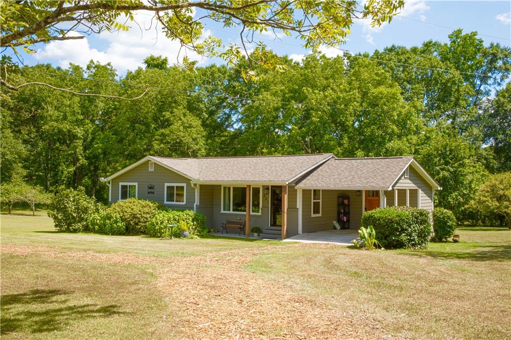 Welcome to Adytum—your private sanctuary just minutes from Downtown Senoia. This beautifully updated 3-bedroom, 2-bath home offers charm, comfort, and space to create. Inside, you’ll find hardwood floors, an open-concept kitchen with abundant natural light, side laundry room, and a mudroom with extra storage. But the magic and beauty continues outside, the property boasts a massive 1,200 sq ft detached garage—air-conditioned and capable of housing up to six vehicles or your dream workshop/studio setup—plus an attached covered carport for additional parking. Enjoy fresh pears, apples, muscadines, from your own mature fruit trees, with nearly two acres, plenty of room to grow even more. Whether you’re relaxing under the shade trees or working in your creative zone, this lovingly maintained home offers a rare blend of peaceful living and practical amenities—all just 40 minutes from Atlanta, 10 minutes from Downtown Senoia and a lovely local park just two minutes away.