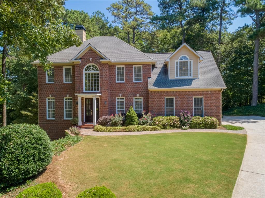 Welcome to this beautifully landscaped home tucked away on a quiet circular cul-de-sac. A rare opportunity offering flexible living spaces, outdoor charm, and a fully finished basement. Step inside through stunning custom-stained mahogany front doors with beveled glass into a grand entry foyer. A double-sided fireplace anchors two spacious living areas, perfect for entertaining or setting up a home office. The kitchen is both stylish and functional, featuring Thomasville cabinetry, granite countertops, a breakfast bar, built-in coffee station, and a bright breakfast nook with built-in bench seating. Enjoy dining al fresco on the expansive Trex deck; or start your day on the cozy side porch overlooking the private lot. Upstairs, the oversized primary suite is privately situated apart from the other bedrooms and features tray ceilings, two custom walk-in closets, and a spacious en-suite bath. Three additional bedrooms and a full hall bath complete the upper level. Downstairs, the finished basement offers 9-foot ceilings, a large open living space, built-in counter and fridge, plus ample storage. Perfect for entertaining, hobbies, or even a home gym.