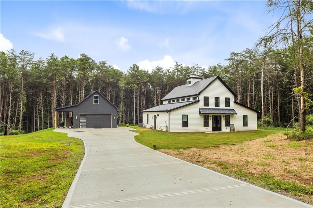 MOTIVATED SELLERS, ready to negotiate! Don't miss this rare opportunity to own a custom luxury barndominium on over 5 private acres! Welcome to 24 Plantation Rd NW – A Custom-Built Luxury Barndominium on 5.24 Private Acres
Step into a rare blend of sophistication and country charm with this custom-built 3-bedroom, 3-bath barndominium tucked away on 5.24 peaceful acres in beautiful Adairsville. Designed for both elegance and comfort, this one-of-a-kind home offers 2,576 square feet of thoughtfully designed living space where modern features meet timeless rural appeal.
The open-concept layout offers a bright, airy atmosphere and smooth flow throughout. The spacious kitchen opens directly to a private patio, perfect for outdoor dining or simply enjoying the quiet surroundings. The primary suite is a peaceful retreat with its own patio access, ideal for morning coffee or unwinding at the end of the day.
Upstairs, a loft space overlooks the main living area and opens to a second-story deck, offering beautiful views of the land and a perfect place to relax or entertain.
A major bonus is the detached 2-car garage with a large upstairs loft—ready to be transformed into a guest suite, studio, home office, or additional living space.
Just minutes away, enjoy local favorites like Barnsley Resort & Gardens, offering luxury amenities such as golf, spa, and fine dining, and Pettit Creek Farms, known for seasonal events and family fun. You’ll feel miles away from it all, yet still have easy access to Cartersville, Rome, and I-75.
If you’re looking for a luxury home with privacy, space, and character, 24 Plantation Rd NW delivers a truly special opportunity. Come experience the beauty and lifestyle this custom barndominium offers—schedule your private showing today.