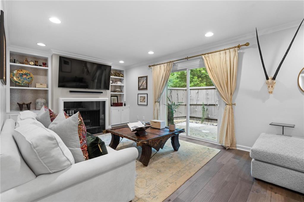 Welcome to this rare opportunity: a renovated, move-in ready end unit in The Ivys, a well-maintained community in the heart of Buckhead. A stones throw to Chastain Park, popular restaurants like Superica, Bartaco, and Chopt, shopping, schools, and the Blue Heron Nature Preserve. This light-filled home features hardwoods throughout. The formal dining room off the foyer seats 10 and opens to an updated kitchen with ample cabinet and counter space. The spacious living room includes a wood-burning fireplace, custom built-ins, and French doors leading to a private patio and a wooded view—ideal for indoor-outdoor living and entertaining. The main level also includes an updated half bath, huge laundry room with extra shelving, and two storage closets. Upstairs, two large bedrooms (converted from the original three-bedroom layout) offer flexibility and can easily be reconfigured. The sizable primary suite features a newly renovated bathroom with gorgeous updated tile, vanity, and a glass-enclosed shower. The secondary bedroom includes great natural light, an office (that could be turned back into a separate 3rd bedroom), and its own updated en-suite bathroom. Multiple hall closets also provide additional storage.
This is a special units in one of the most private, desirable locations within the Ivys! There is guest parking along with the deeded spots directly outside the front door. The community is dog-friendly, social, and has its own pool and tennis courts. Located in a quiet, tucked-away location off Roswell Road, yet in the middle of Buckhead also convenient to I-85, GA-400, and the Piedmont/Peachtree corridor.