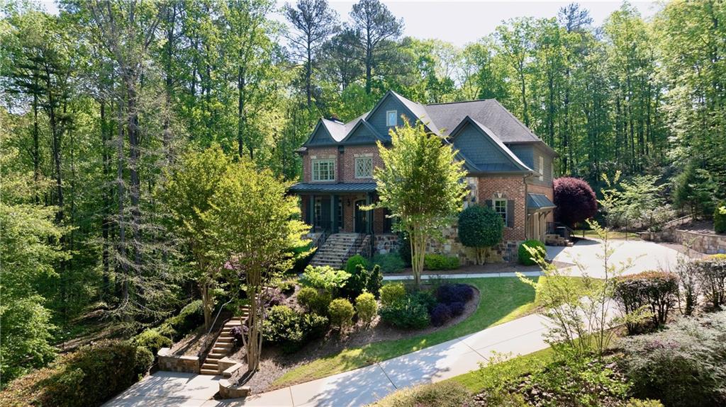Discover unparalleled luxury in this exceptional custom home, nestled on a serene ¾-acre lot within the prestigious Anderson Farm community of Marietta. This lovely community is only a couple of miles from the charming Marietta Square. Situated on a private cul-de-sac, this residence offers breathtaking views of Kennesaw Mountain from the second floor, providing a picturesque backdrop to your daily life. The home features all-new designer-selected paint both inside and out complemented by new chandeliers and light fixtures that create a fresh and inviting atmosphere. A beautiful screened-in rear porch opens to a natural stone patio with a custom outdoor fireplace, and pool site - perfect for entertaining or relaxing evenings. The primary suite boasts a cozy sitting area, a Juliette balcony, and brand-new carpeting. A unique custom closet, transformed from the fifth bedroom, includes a dedicated shoe room. This space can easily revert to a fifth bedroom if desired. The full, unfinished basement is equipped with a Mitsubishi split unit, a roughed-in half bath and washer/dryer connections. Ideal for a gym, workshop, or additional storage, it is also framed for future living spaces and bedrooms. Enjoy the practicality of laundry facilities on the upper level near the bedrooms, with an additional hookup in the main-level mudroom. The upper level also features a very gracious bonus room. The three-car garage features beautiful wood-stained doors, adding to the home's charm. The current homeowner owns the adjacent lots, 306 and 314 Anders Path, and is offering the buyer the right of first refusal, presenting a rare chance to expand or ensure privacy. Embrace the blend of luxury and tranquility in this phenomenal custom home at Anderson Farm. With its exquisite features and prime location, it's more than a residence—it's a lifestyle.
