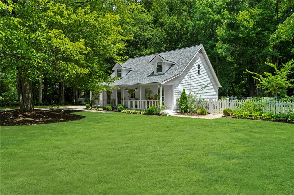 Welcome to your completely renovated haven in the heart of downtown Alpharetta, where charm meets modern sophistication on a sprawling .69-acre lot! This delightful 3br 2.5ba home offers the perfect blend of comfort and style. Step inside to discover stunning white oak wide plank hardwood floors that flow throughout the home, creating warmth and elegance in every room. The primary suite is conveniently located on the main level, spa like bathroom with floating vanities, frameless glass shower and designer lighting. The living room captivates with a vaulted ceiling and cozy wood-burning fireplace complete with gas starter. The open kitchen serves as the heart of the home, featuring stainless steel appliances, oversized island, designer tile, quartz countertops and a charming breakfast nook with bay windows that frame views of the beautifully landscaped outdoor entertaining area. A spacious dining area on the opposite side of the kitchen provides ample space for hosting family gatherings. Secondary level offers two bedrooms and a full bathroom, with ample storage and closet space. Completely redesigned landscape featuring boulder walls, pea gravel entertaining areas, complete irrigation system, lush Zoysia sod, mature trees, and plantings all enclosed within a quintessential white picket fence. Thoughtfully designed low-voltage lighting illuminates the home and yard, with enchanting firefly lights dancing among the trees from dusk to dawn. Enjoy a short stroll to your favorite restaurants and shops, welcome home!