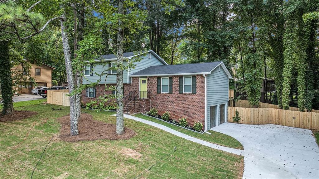 *Track record matters.* When the team behind your home's renovation has successfully transformed hundreds of properties across metro Atlanta, you know you're in good hands. Welcome to 1028 Martin Road, where decades of experience meet uncompromising excellence. Priced at $299,900 to bring immediate attention in today's market. Now, in a market flooded with cookie-cutter new builds and corner-cutting flips (where everything is apparently 'better than new!' and 'won't last long!'), this meticulously updated split-level offers something genuinely rare: real character enhanced by sophisticated modern upgrades done right. No lazy agent hyperbole here. No copy/paste descriptions drowning in desperate exclamation points. Just quality that speaks for itself. Start with what you'll notice from the curb—sturdy red brick foundation grounding sage green hardi-plank siding, crisp white trim harmonizing with rich olive shutters. And yes, a whimsical pop of chartreuse at the front door, hinting at thoughtful surprises inside. Those towering pines? They form a natural canopy that drops temperatures and fills your property with that peaceful whisper of pine needles. Let's step inside and feel the difference. Contemporary gray plank flooring flows seamlessly throughout, while the living room sets the tone with sophisticated palette and thoughtful lighting—perfect for intimate evenings or lively gatherings. The kitchen is where this home really shines. Slate-gray cabinetry reaches the ceiling, granite countertops stay cool to the touch, and professional stainless appliances make cooking a joy. No need for 'chef's dream!' exclamations when quality speaks for itself. The adjacent dining room handles everything from homework to holiday feasts with equal grace. Upstairs, three spacious bedrooms offer true private retreats. The primary suite feels genuinely peaceful as updated windows buffer outside noise while morning light filters in softly. There's a walk-in closet that actually fits your wardrobe, and a beautifully remodeled primary bath. Two additional bedrooms share a second full bathroom with spa-like finishes, one already showcasing home office potential. But here's the game-changer: a spectacular lower level. Nearly 600 square feet with cozy fireplace, currently the ultimate recreation room but ready to become whatever you need—theater, teen suite, creative studio. Light a fire on cool evenings and watch the space transform. And with third full bathroom, laundry, and direct garage access daily life flows seamlessly. Step outside to your private retreat beneath majestic pines. The elevated deck overlooks a landscaped yard where mature trees provide natural shade and fresh pine scent. Sure, we could type 'great for entertaining!' and move on. But when you've got natural architecture and a deck positioned for morning coffee and evening wine, why settle for shortcuts? This space deserves better. So do you. Location-wise, you couldn't ask for more. This established Stone Mountain neighborhood radiates pride, yet you're minutes from Highway 78 and I-285. Stone Mountain Park's 3,200 acres feel like your extended backyard. The Village provides eclectic shops and restaurants where neighbors know each other. Quality schools, Yellow River Trail, Mall at Stonecrest—everything's covered. This isn't some surface flip. We're talking comprehensive renovation—new roof, updated systems, designer finishes. Every detail reflects what happens when experience meets vision. Perfect whether you're first-timers skipping the starter phase, growing families needing space, or savvy investment minded buyers recognizing opportunity. Finding 2,036 square feet of thoughtfully updated space at this price point is increasingly difficult. We could hit you with urgency tactics, but let's be honest—you've read enough. Time to trust your own eyes over any agent's adjectives. When you're ready to see what quality looks like, 1028 Martin Road speaks for itself.
