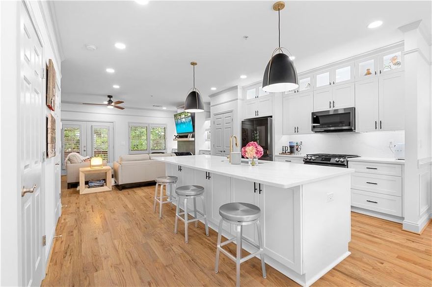 COMPLETELY RENOVATED Luxury End-Unit Townhome – Walk to Downtown Alpharetta & Avalon! Perfectly situated in the heart of Alpharetta, this stunning 4-bedroom, 3.5-bath 2 car garage fee-simple townhome offers an unbeatable combination of location, modern upgrades, and thoughtful design. Just steps from downtown, Avalon, top restaurants, shopping, parks, and The Alpha Loop, this home provides both convenience and elegance. Inside, three levels of beautifully refinished living space feature rich 3/4-inch hardwood floors throughout, including both staircases. The completely renovated kitchen is a true showpiece, with brand-new cabinetry, a striking 13-foot custom island with extra storage, quartz countertops, and black stainless steel appliances. A custom-designed walk-in pantry with hardwood organizers ensures effortless organization, and a second pantry for additional storage. The spacious dining area flows seamlessly into the inviting family room, where a modern tiled fireplace is flanked by custom built-in bookcases. The primary suite feels like a private retreat, with its raised ceiling, custom closet system, and a fully remodeled spa-like bath featuring new tile walls, vanities, countertops, and fixtures. Each additional bathroom has been updated with high-end finishes, including new tile, sleek vanities, and designer lighting. The entry-level suite offers a large bedroom with an en-suite bath, perfect for guests or a private home office. Every inch of this home has been designed for comfort and style, with custom color-matched interior shutters on every window, upgraded lighting throughout, and an extended deck with a covered overhang—ideal for outdoor entertaining. The newly renovated laundry room features custom cabinetry and designer tile, while additional custom storage solutions enhance both the master bedroom and bathrooms. New HVAC, three-sided brick construction, and refreshed exterior lighting complete this move-in-ready masterpiece. With luxury upgrades, impeccable design, and a prime walkable location, this townhome is a rare opportunity in Alpharetta. HOA includes water/sewer and trash service! Don’t miss your chance to make it yours!