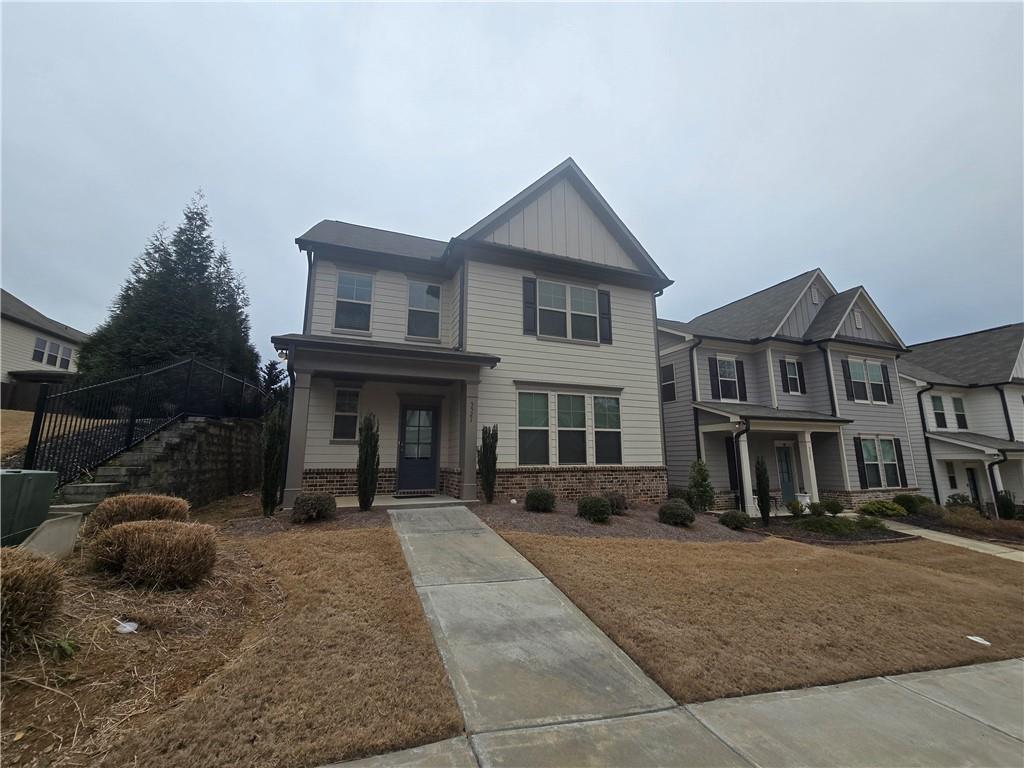 Craftsman-style home with covered porch, brick siding, and board and batten siding