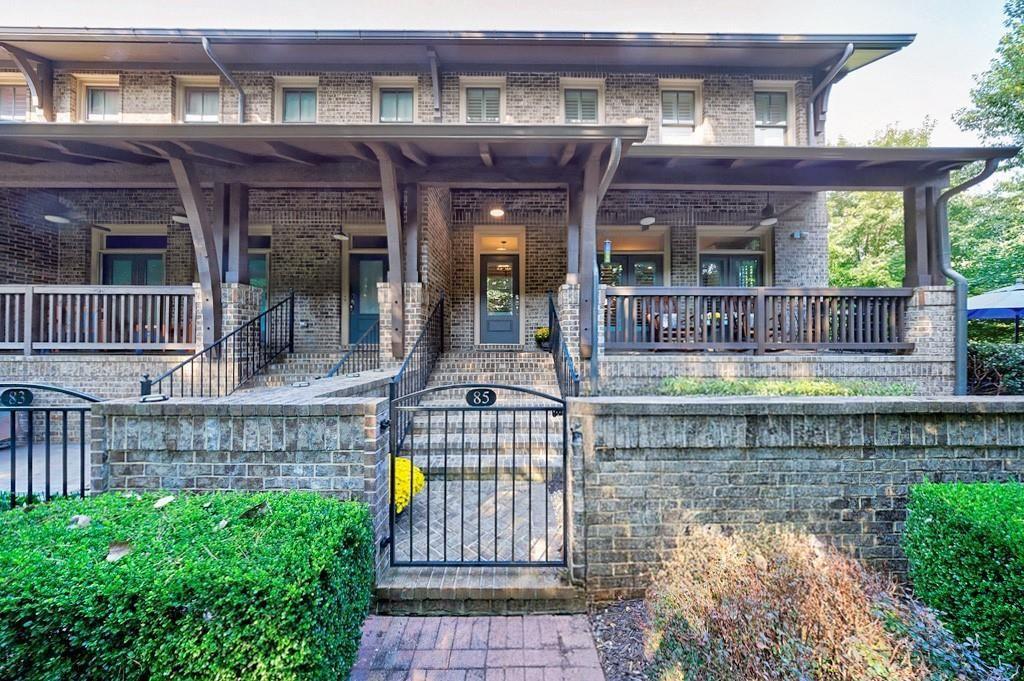 Tucked down a quaint brick path framed by trees, this stunning brownstone in the coveted Providence community redefines in-town living in Historic Roswell—just steps from the vibrant shops and restaurants of Canton Street. Enter through a charming iron gate to an expansive brick courtyard with a built-in grill, dining area, and firepit. A rocking chair front porch overlooks the lushly landscaped entry, offering both beauty and privacy. Inside, the main level boasts 10-foot ceilings, engineered hardwoods, and three elegant living spaces that live like a single-family home. A curved wall defines the spacious family room featuring a stone gas fireplace with wood mantle, built-in bookcases, and window seats. Two sets of French doors open to the front porch while side windows bathe the space in natural light. A gracious dining area easily accommodates a banquet-sized table for gatherings with family and friends. The gourmet kitchen is a true showpiece with custom cabinetry, exotic granite island, and a keeping room. Holiday entertaining is effortless with a 60” six-burner Thermador range with griddle and double ovens, a pot filler, paneled SubZero refrigerator, wine bar with cooler, and walk-in pantry. Upstairs, the primary suite retreat offers a sitting area, beverage fridge, custom walk-in closet, and spa bath with soaking tub and frameless shower. Two secondary bedrooms with large closets and a full bath complete this level. The finished terrace level adds incredible flexibility with a true theater room and serving bar, full bath, flex space for office/gym/guests, and a built-in mudroom. The home is elevator-capable for added convenience. Providence offers pocket parks, an outdoor pavilion with fireplace, and a dog park—all just steps from Roswell’s dining, shopping, coffee shops, and festivals. 85 Webb Street is a stunning retreat in the heart of it all. Love Where You Live!
