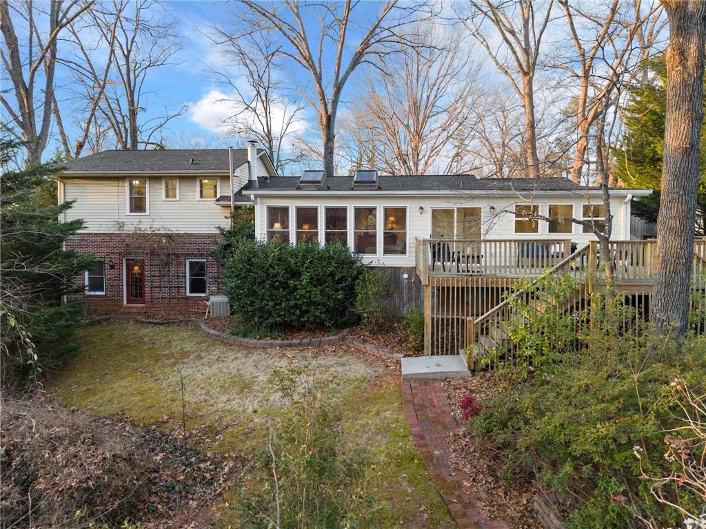Enchanting lakeside retreat nestled in the heart of Gainesville just steps from Wessell Park! This home offers an unparalleled blend of elegance, comfort, and nature. Fronting Lake Lanier without the hassle of a dock, the property is perfect for launching your kayak or paddleboard right from your backyard. Step inside to find a completely renovated gourmet kitchen, designed to impress with high-end finishes and modern conveniences. Hardwood floors flow throughout the home, complementing the warmth of a real wood-burning fireplace and the charm of built-in bookshelves. The sunroom, featuring a breathtaking wall of windows, brings in natural light and serene views of the whimsical, private backyard surrounded by mature woodlands. Every bathroom is beautifully updated and features luxurious heated tile floors for ultimate comfort. The versatile basement serves as a perfect guest suite, teen hangout, or bonus room to fit your lifestyle. Outside, the inviting brick-paved courtyard offers a welcoming entrance and an ideal spot to enjoy your morning coffee. This home is a rare gem blending modern upgrades with timeless character, all in a prime Gainesville location. Don't miss this opportunity to experience the charm of lakefront living.