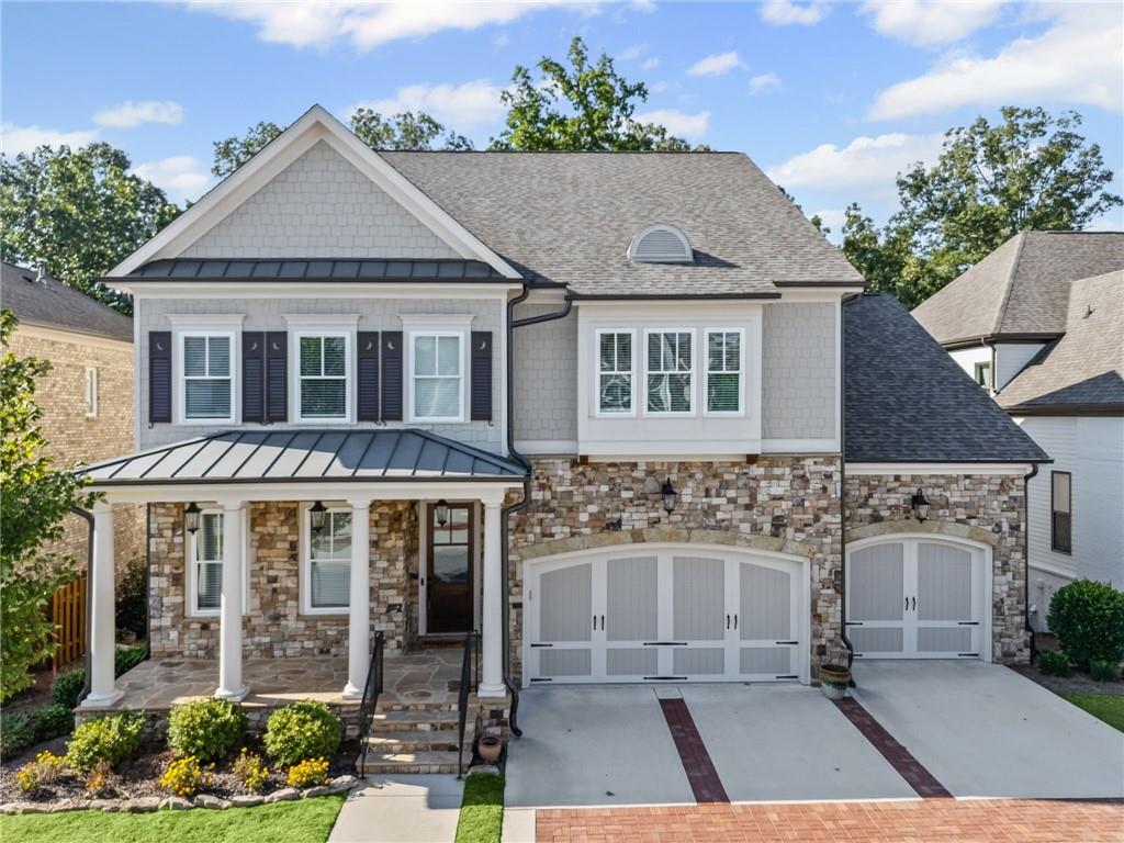 Welcome to the pinnacle of elegance and comfort in the prestigious, gated community of Bellmoore Park—where this stunning residence perfectly balances refined design, thoughtful upgrades, and family-friendly functionality. Situated on a premium, private lot backing to serene wooded greenspace, the home radiates curb appeal from the moment you arrive. A charming front porch invites you inside to a beautifully curated interior, where wide-plank hardwood floors, custom designer finishes, and sophisticated details set the tone throughout.
The main level offers a versatile layout ideal for multi-generational living, complete with two spacious bedrooms—perfect for guests, teens, in-laws, or a dedicated home office. Each bathroom showcases designer tilework, upgraded cabinetry, and elegant furniture-style vanities, creating a consistent high-end aesthetic. The expansive open-concept living area makes entertaining effortless, with a formal dining room flowing into a warm and inviting family room anchored by a floor-to-ceiling stone fireplace. A wall of windows bathes the space in natural light, while the chef’s kitchen stands as the heart of the home—featuring a large center island, quartz countertops, stainless steel appliances, double ovens, under cabinet lighting, and extensive upgraded cabinetry.
Step through double doors to the extended deck, thoughtfully designed with both covered and uncovered spaces—ideal for morning coffee, evening wine, or simply enjoying the tranquil wooded backdrop. Adjacent to the kitchen, a convenient mudroom with custom built-ins, full bathroom, and additional bedroom add everyday functionality.
Upstairs, a beautifully designed landing with hardwood floors and wainscoting leads to three spacious secondary bedrooms. The Jack-and-Jill layout offers a dual-sink vanity and stylish finishes. The Bonus Room/Bedroom includes a built-in window seat which adds charm and practicality. The show-stopping owner’s suite is a true retreat, featuring a tray ceiling, expansive layout, spa-like bath with his-and-her vanities, soaking tub, fully tiled shower, and an oversized walk-in closet with his-and-her sides of custom organization.
The full daylight basement is ready for your personal touch—whether a home theater, gym, playroom, or in-law suite. Step outside to a beautifully manicured backyard and extended patio, perfect for entertaining or peaceful relaxation. A three-car garage and Bellmoore Park’s premier amenities—including resort-style pools, tennis courts, clubhouse, fitness center, and access to top-rated schools—complete the lifestyle.
And if you and your family WANT MORE? You can enjoy the highly anticipated Medley Development (soon), Johns Creek’s visionary new Town Center located just minutes away. Spanning 43 acres, Medley will bring an exciting mix of upscale dining, boutique shopping, entertainment, a boutique hotel, and thoughtfully designed green spaces together in a vibrant, walkable community hub. With a central plaza set to host year-round events, live music, and festivals, along with modern townhomes, luxury residences, and lifestyle office space, Medley is designed to be the city’s true gathering place. Scheduled for completion in 2026, this transformative development will offer Bellmoore Park homeowners unparalleled convenience and access to the very best of Johns Creek’s future.