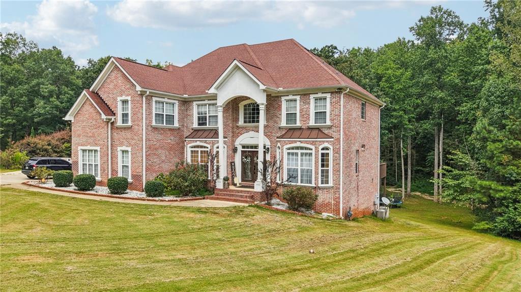 Situated on a 1 ACRE lot in a quiet CUL-DE-SAC, this beautiful three-sided brick home on a FULL FINISHED BASEMENT offers timeless curb appeal, abundant living space, and amenities that include a resort style pool and tennis courts. With a three-car side-entry garage, extended parking pad, and spacious driveway complete with a basketball hoop, this home provides both elegance and function for everyday living. Professional landscaping, a sprawling lawn, and a covered double-door entry set the tone for what’s inside. Step into the two-story foyer, where hardwoods and crown molding flow into a formal dining room with wainscoting and a formal living room (or home office), both highlighted by charming bay windows. The heart of the home is the two-story family room, boasting a wall of palladium windows, a striking stone fireplace, and an abundance of natural light. The chef’s kitchen is equally impressive with stainless steel appliances including a double wall oven, tile backsplash, breakfast bar, center island, and plenty of counter space. From here, enjoy direct access to the deck for seamless indoor-outdoor living. A main-level en-suite bedroom with full bath access is perfect for guests. Upstairs, the primary suite is a true retreat featuring double tray ceilings, a cozy fireplace, French doors leading to a private deck, an expansive walk-in closet plus two additional closets, and a luxurious bath with a jetted tub, double vanity, and frame-less shower with a rainfall shower head. Three additional bedrooms share a well-appointed Jack-and-Jill bath. The full finished basement offers incredible flexibility with sleek marble-like tile floors, full bathroom, multiple bonus areas for a billiards area, media room, or second living space, with two potential bedrooms. With walk-out access to the backyard, this level could easily be extended with a patio for the perfect private apartment or in-law suite setup. Outdoors, enjoy wooded views, a tranquil creek bank, and a spacious yard with a fire pit, perfect for gatherings. Stairs from the main-level deck make the backyard easily accessible for entertaining or relaxing. Just outside the hustle and bustle while still being conveniently located near schools, major highways for an easy commute, park and recreational facilities, as well as grocery option. This home combines classic style, functional design, and a prime location, making it an opportunity you won’t want to miss!