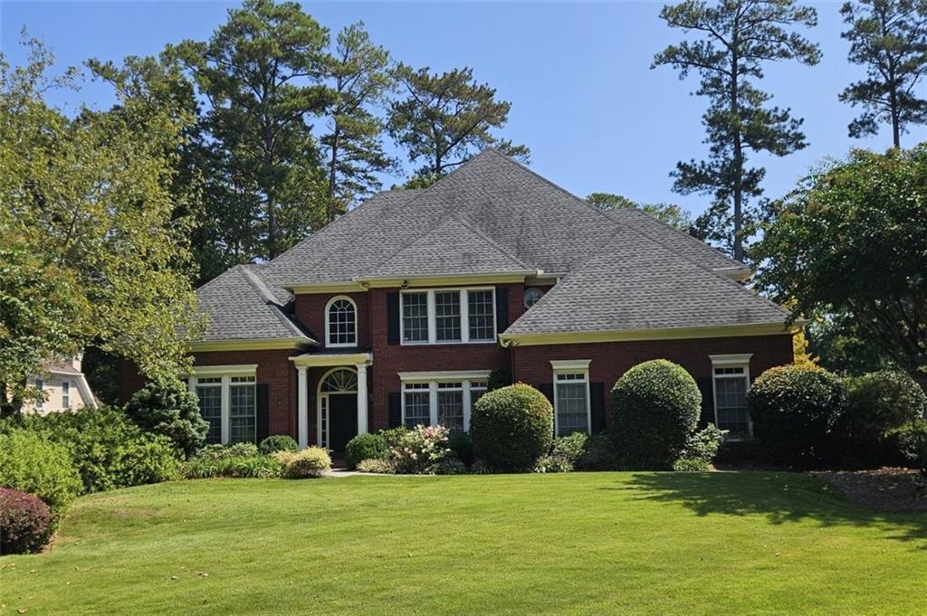 Rare four-sided brick beauty on a quiet cul-de-sac. This elegant and spacious home offers a low maintenance brick exterior, a level lot, and a highly sought-after primary suite on the main level — all tucked away on a peaceful street in the desirable Wheeler Magnet School district. Inside, you’re greeted by a dramatic two-story foyer flanked by a large open dining room and a soaring two-story family room with a wall of windows and French doors that lead to the patio, fireplace with gas logs and more. The main level also includes a private home office with coffered ceilings, a separate laundry/mud room, and gorgeous real hardwood floors throughout. The oversized white kitchen is a chef’s dream, featuring double ovens, a gas cooktop, a center island, pantry, and abundant cabinetry. It opens to a vaulted family room with a second fireplace and an adjoining breakfast room with access to the patio — perfect for entertaining. The main-level owner’s suite boasts tall, coffered ceilings, two walk-in closets, dual vanities, a jetted soaking tub, separate shower, and private water closet.
Upstairs, you’ll find three generous bedrooms — one with an en suite bath, and two connected by a Jack-and-Jill bath — plus a large bonus room with a closet that could serve as a fifth bedroom, media room, or playroom. Architectural shingled roof features 6-inch gutters with leaf guards. Outside, the fenced backyard is a landscaper’s dream, with a 5-zone irrigation system and a lush array of flowers, shrubs, and exotic trees. This home combines timeless design, abundant space, and an unbeatable location — all within a small, well-maintained neighborhood with an HOA that cares for the entrances.