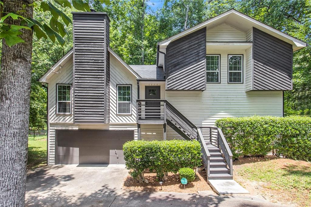 Cool and contemporary, this updated home sits in a private setting with a serene creek and the soothing sounds of birds in the background. The main living area features vaulted ceilings, a cozy fireplace, and large windows that fill the space with natural light. The kitchen blends style and function with white shaker cabinets, quartz countertops, a custom baker's counter, tile backsplash, and a stainless steel gas range, dishwasher, and hood vent. The inviting primary suite offers a walk-in closet, barn door entry to the ensuite bath, double vanities, and a spacious tile shower with glass doors. A large bonus room with a full bath and private deck access makes the perfect guest suite, office, or extra bedroom. Step out onto the back deck and enjoy the peaceful sights and sounds of your own nature retreat -- this is the one you've been waiting for!