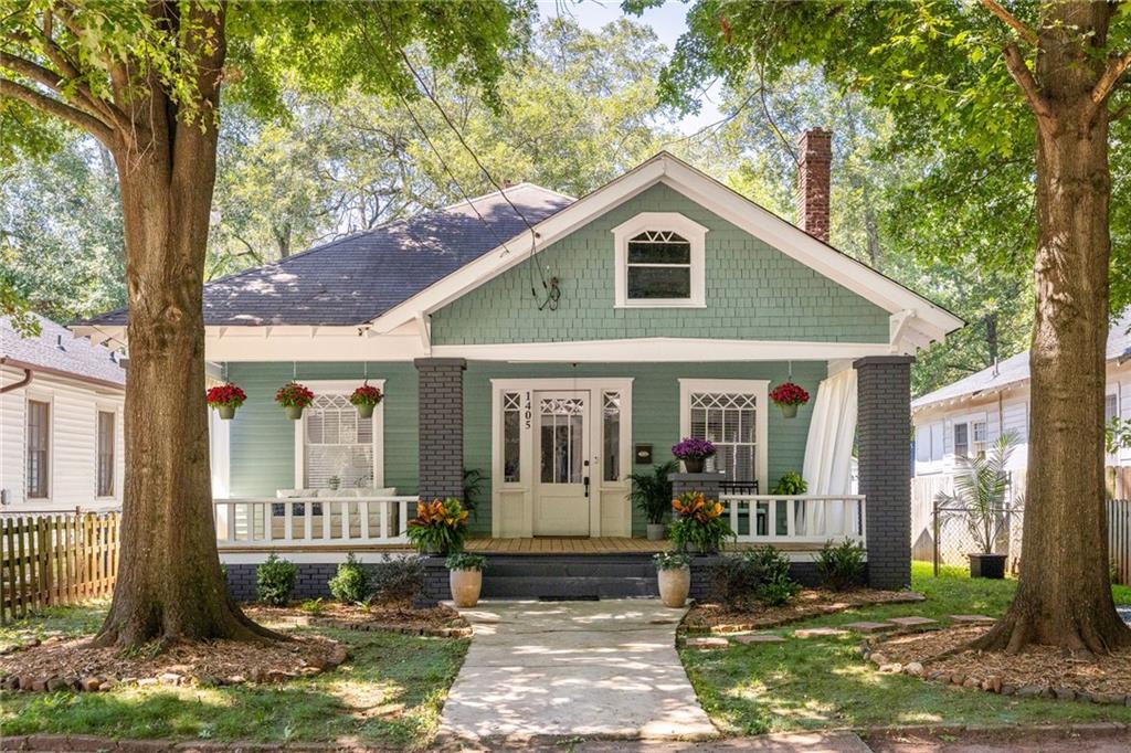 A century ago, this Country Victorian was built in Capitol View, a neighborhood once connected to Downtown Atlanta by a trolley line starting at Dill Avenue. The streets here were designed to be gracious and welcoming-tree-lined boulevards with deep front yards and homes set proudly back from the road. Today, 1405 Graham still sits on that same leafy street. Where trolleys once carried neighbors into the city, the Atlanta BeltLine now serves as your pathway-whether by foot, bike, or scooter-echoing the way streetcars linked these communities a hundred years ago. Arrive however you like, and you'll be greeted by two time-honored oak trees and a front porch that spans the full length of the home, setting the stage for the character within. Step inside through the front door framed by diamond-pane windows, and you're welcomed into a true Country Victorian. Inside, original built-ins anchor a coal-burning fireplace, surrounded by soaring ceilings and hardwood floors. The dining room features a canted bay window with matching diamond detail, flooding the space with natural light and highlighting a second original fireplace. The bright kitchen offers solid stone counters, a breakfast bar, and sleek white shaker cabinetry-modern function that pairs seamlessly with historic charm. The primary suite enjoys abundant natural light and a private bath, while the secondary bedroom captures the third original fireplace and connects easily to a renovated hall bath. Out back, the yard is oversized and full of potential, ready for play, gardens, or gatherings. Beyond your own grounds, you're just minutes from the Lee + White development, home to Monday Night Brewing, Wild Heaven, and an eclectic food hall. The nearest BeltLine access is only blocks away, and Graham Avenue dead-ends into Perkerson Park-50 acres of green space with tennis courts, ball fields, and Atlanta's number one rated disc golf course (udisc.com). 1405 Graham is more than a home-it's a piece of Capitol View history, updated for today's lifestyle, every detailed considered including a roof replaced just 5 years ago but still rooted in the neighborhood's century-old story.