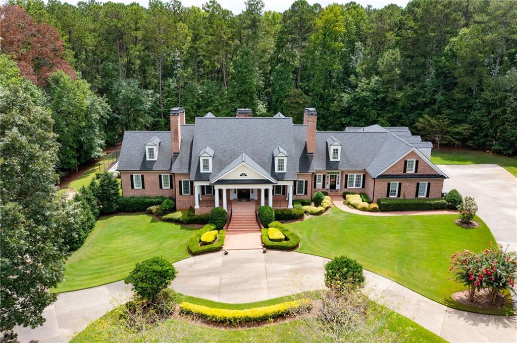 Motivated Seller! Every inch of this home, sitting on 2.6 acres bordering Corps of Engineer property, was masterfully designed by the original owner for beauty, functionality and limitless options for relaxation or gathering of family and friends. Main level garage has 4 stalls including a 15 ft high bay deep and tall enough for your boat / recreational vehicle. The elevator provides a convenient way to access each floor with ease. The kitchen is truly stunning, perfectly designed for both lavish dinner parties and cozy family nights at home. Featuring a mix of soapstone and granite countertops, two ovens, two microwave/convection ovens, two warming drawers, custom cabinetry, a 6-burner Thermidor cook top, a copper pot filler, under-cabinet and glass cabinet lighting, two dishwashers, two refrigerators (including a built-in Sub Zero refrigerator/freezer), a butler's pantry with an additional dishwasher and sink, and a custom pantry with pull-out storage and yet another sink—this space ensures that all your culinary needs are effortlessly met. The incredibly spacious Breakfast area and fireside keeping room enhance this space beautifully. The Owner's Suite on the main level boasts private access to the exterior patio and pool, a cozy fireplace, and a triple tray ceiling. The owner's bathroom is both luxurious and beautifully designed, featuring two custom-built closets, a jetted tub, elegant tile, and granite finishes. Attached to the owners suite is the media room which could also be a private office space. The second bedroom on the main level also with a fireplace and en suite bath, offers the perfect potential as an additional primary bedroom. Upstairs you will find the second laundry and the VERY spacious 5 secondary bedrooms. 3 with En suites, 2 with attached private work / play space, all with extra storage and very spacious walk in closets with custom shelving systems!! One has private entrance from the kitchen level garage. The terrace level serves as a complete living space with its own driveway access and a two-car garage. The full kitchen features a large island with seating for four, two built-in microwaves, a sink, dishwasher, abundant cabinetry, and a gas stove hook up. This level also includes a laundry room, spacious rec rooms, a bedroom with a fireplace and private access to the rear patio and pool, a soundproof music room, and plenty of additional storage. The private exterior caters to both relaxation and entertainment. Two large exterior upper and lower patios both have Ceiling fans, recessed lighting and fireplaces, The regulation size court with the adjustable net and high end Sport Court surface is suited for Basketball, pickle ball, badminton or tennis. 45000 gallon heated Gunite pool with tanning ledge and hot tub. Close to Allatoona Creek Park with miles of hiking and bike trails, Pitner Rd Dog Park, Downtown Acworth and top Cobb County Schools