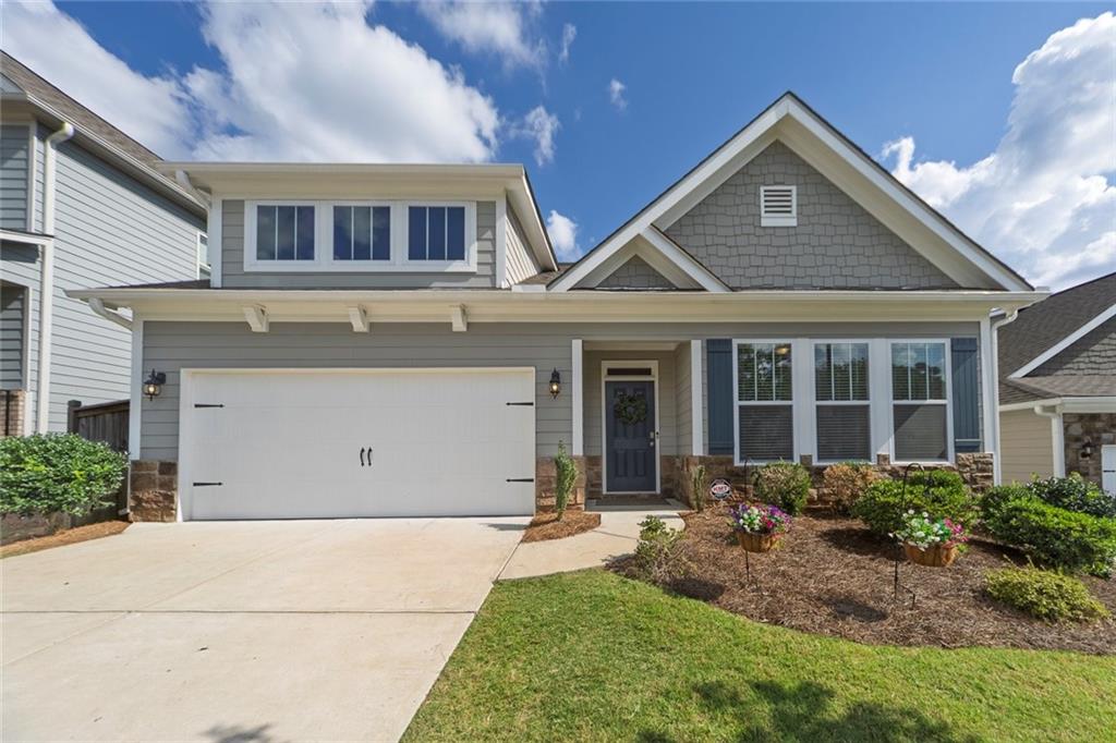 Welcome to your dream home in the desirable Bridgemill Heights — a sought-after newer construction community! This stunning 4-bedroom, 3-bathroom home offers a perfect blend of style, space, and functionality, with the primary suite conveniently located on the main level and a spacious loft/bonus space upstairs. Step inside to find an open-concept floor plan featuring a designer white kitchen with a massive 14-foot quartz island, double ovens and gas range. The kitchen seamlessly flows into the great room, dining area, and breakfast nook — ideal for both everyday living and entertaining. The main level also includes the luxurious primary suite with a spa-like bathroom and oversized walk-in closet, plus two additional bedrooms and a full bath. Upstairs, you’ll love the large versatile loft/bonus area, perfect for a media room, playroom, or office, along with the fourth bedroom and third full bath. Enjoy outdoor living in the private backyard with a pergola, providing the perfect shaded space for relaxing or entertaining. Conveniently located across from Sixes Elementary and just down the road from the brand-new Cherokee Classical Academy, with King’s Academy also close by. Enjoy quick access to both Downtown Woodstock and Downtown Canton, The Outlet Shoppes, and Hobgood & JJ Biello Parks/Sports Complexes. Outdoor enthusiasts will love nearby Lake Allatoona and the many hiking and biking trails, while commuters will appreciate the easy access to I-575. HOA includes lawn maintenance and trash pickup. Optional Bridgemill membership for access to top-tier resort style amenities: pools, tennis, golf and more! Don’t miss making this practically new construction home yours today!